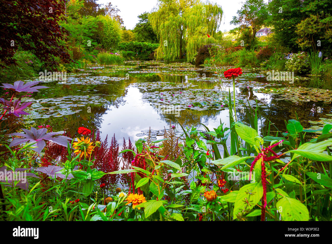 Schöner Garten und Teich mit Clustern aus bunten Blumen, Bäume und Sträucher im Sommer in Giverny. Stockfoto