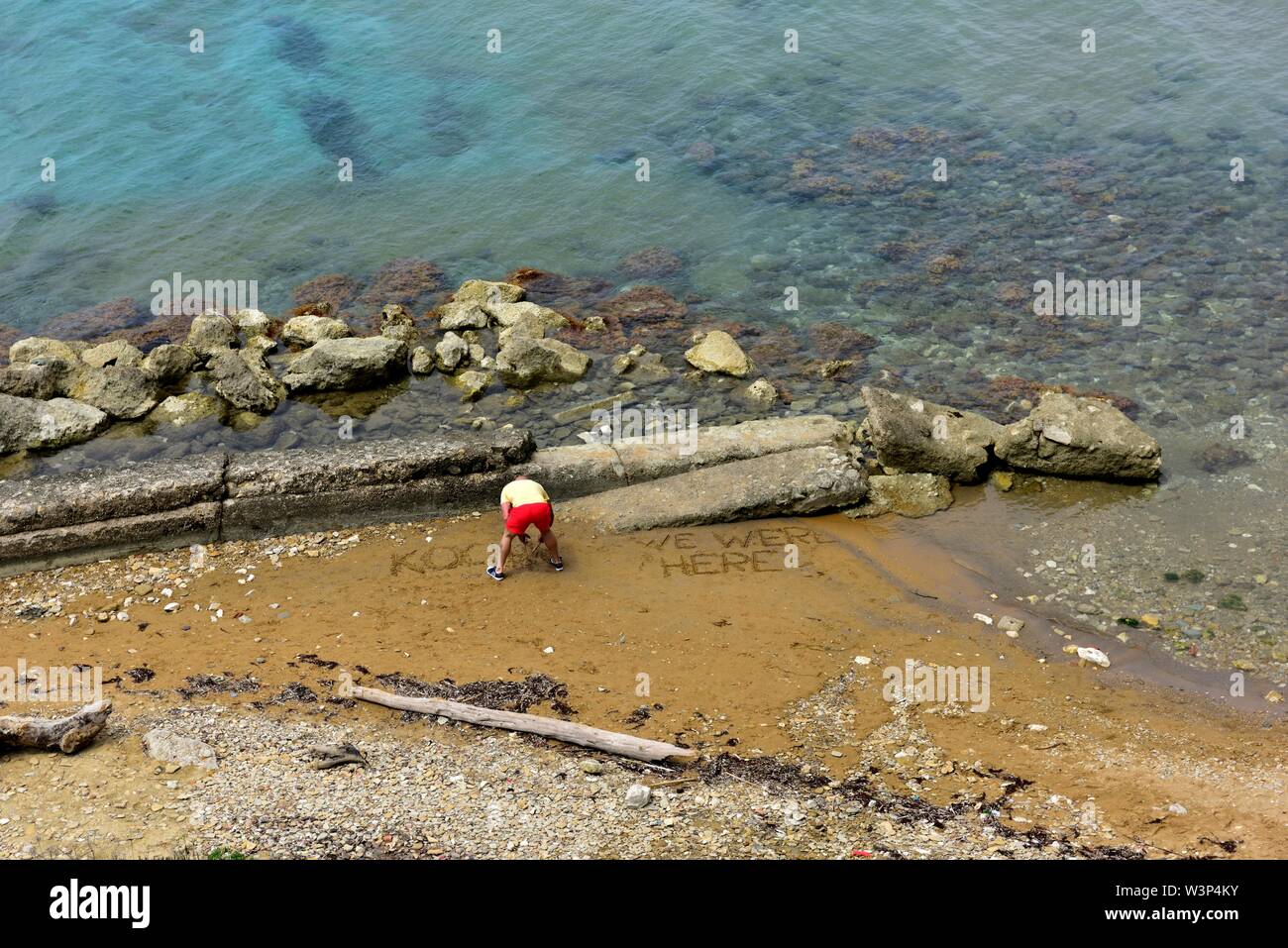 Ein Mann seinen Namen schreiben im Sand am Strand Loggas, peroulades, Korfu, Griechenland, Ionische Inseln Stockfoto