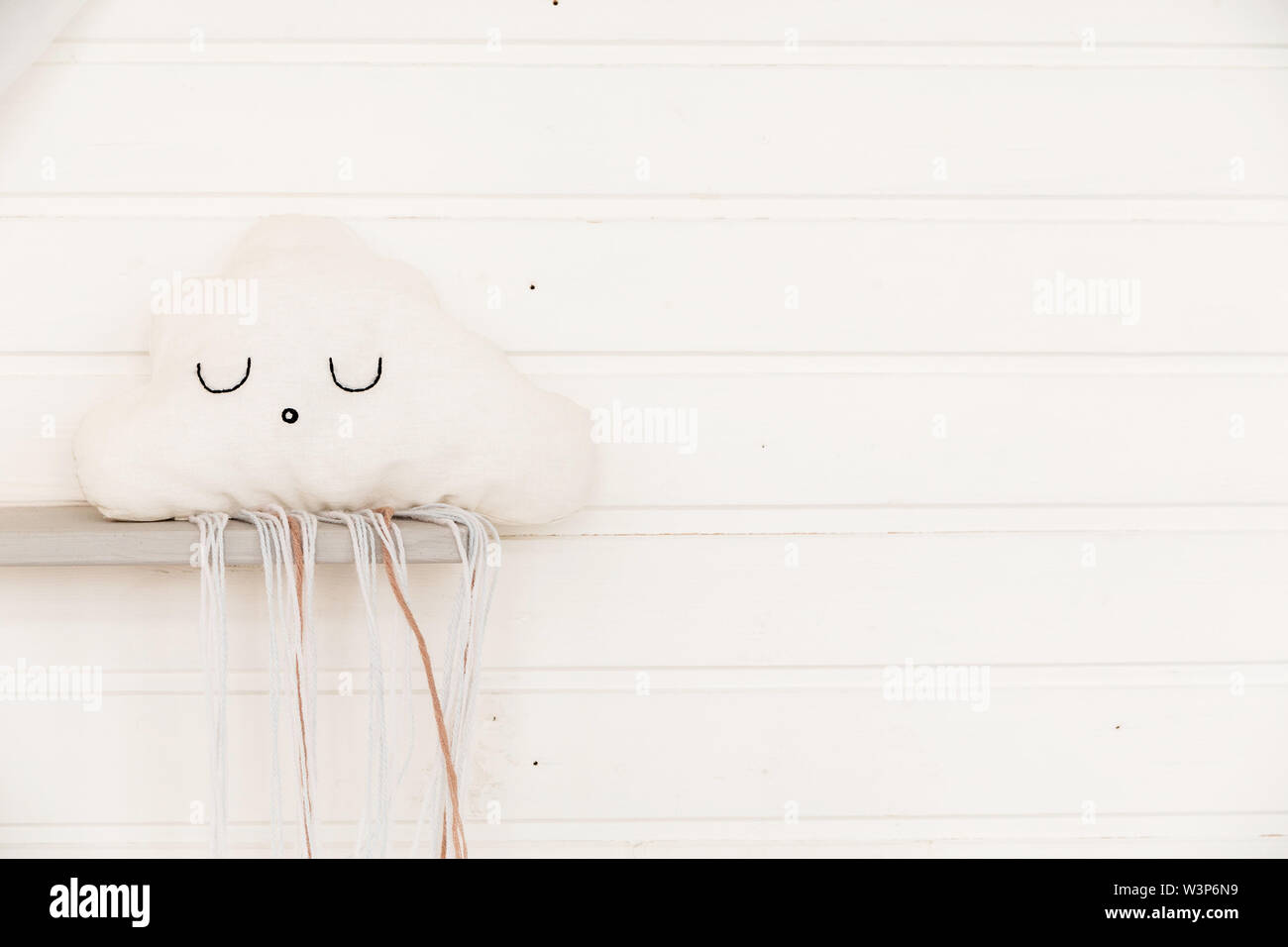 Für Kinder Kissen in der Form einer Wolke auf dem Hintergrund einer Holzwand Stockfoto