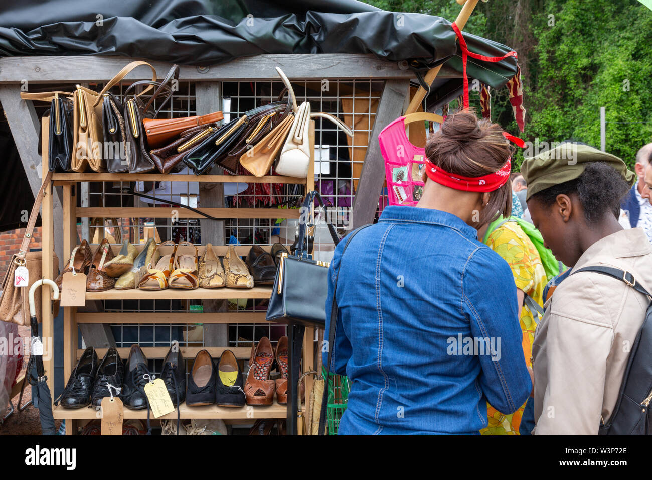 Frauen, die an eine gebrauchte Kleidung in einen Marktstand, Großbritannien Stockfoto