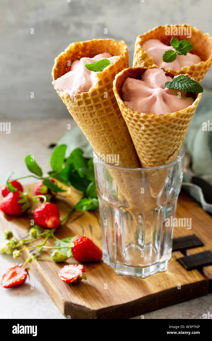 Erdbeer Eis Schaufeln in Kegel auf einem Stein oder Schiefer Tisch. Stockfoto