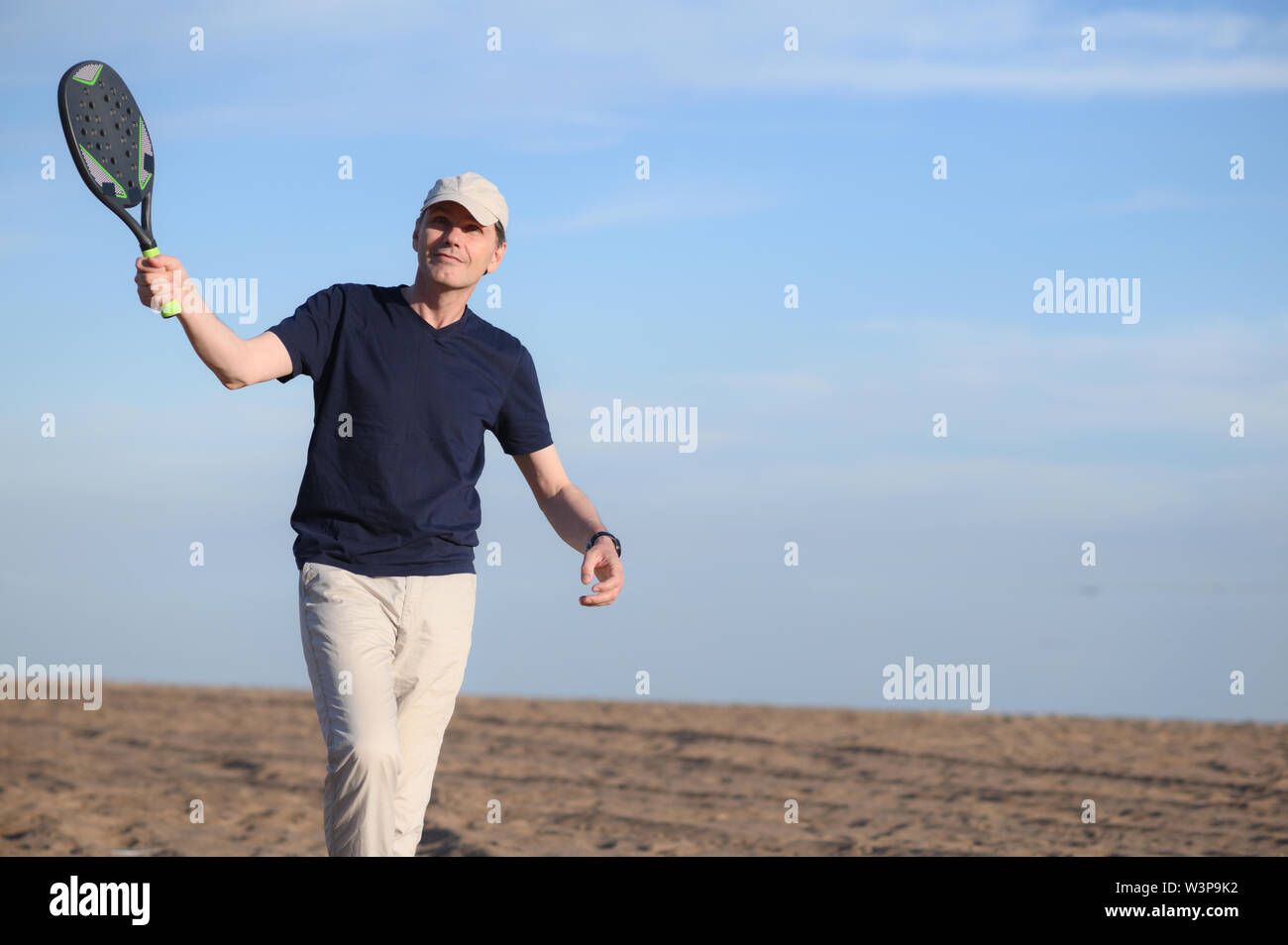 Mann spielt Beach Tennis auf einem sandigen Strand Stockfoto