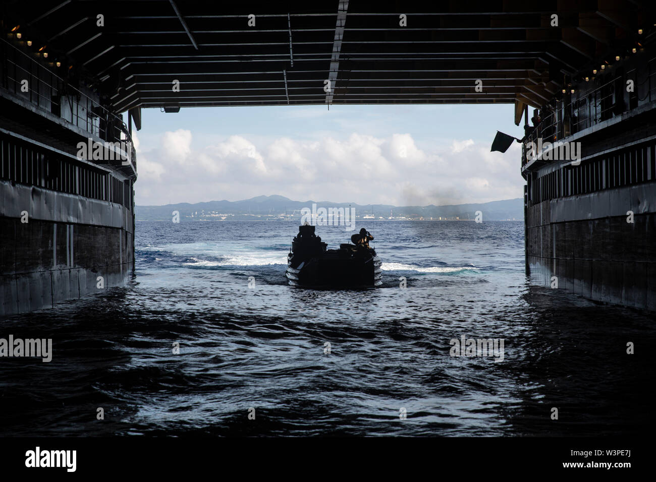 Ein Angriff Amphibienfahrzeug mit AAV Unternehmen, 4. Marine Regiment, 3rd Marine Division, Ansätze der USS Germantown (LSD 42) während einer Shore Schulungsveranstaltung im Camp Schwab, Okinawa, Japan, 16. Juli 2019 zu versenden. AAV Firma durchgeführt, um das Ereignis zu amphibische Kriegsführung der Marine Personal an Bord der Germantown für bevorstehende Übungen zu zertifizieren. (U.S. Marine Corps Foto von Lance Cpl. Hannah Hall) Stockfoto