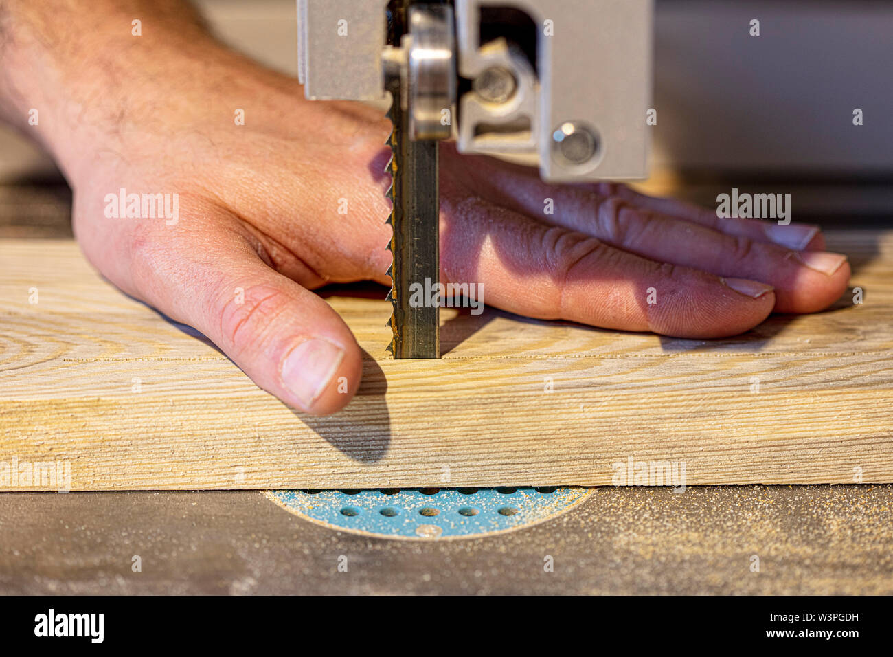 Detail auf der Tischler hand falsch und gefährlich in der Nähe der Band platziert Sägeblatt. Arbeit Sicherheitskonzept Stockfoto