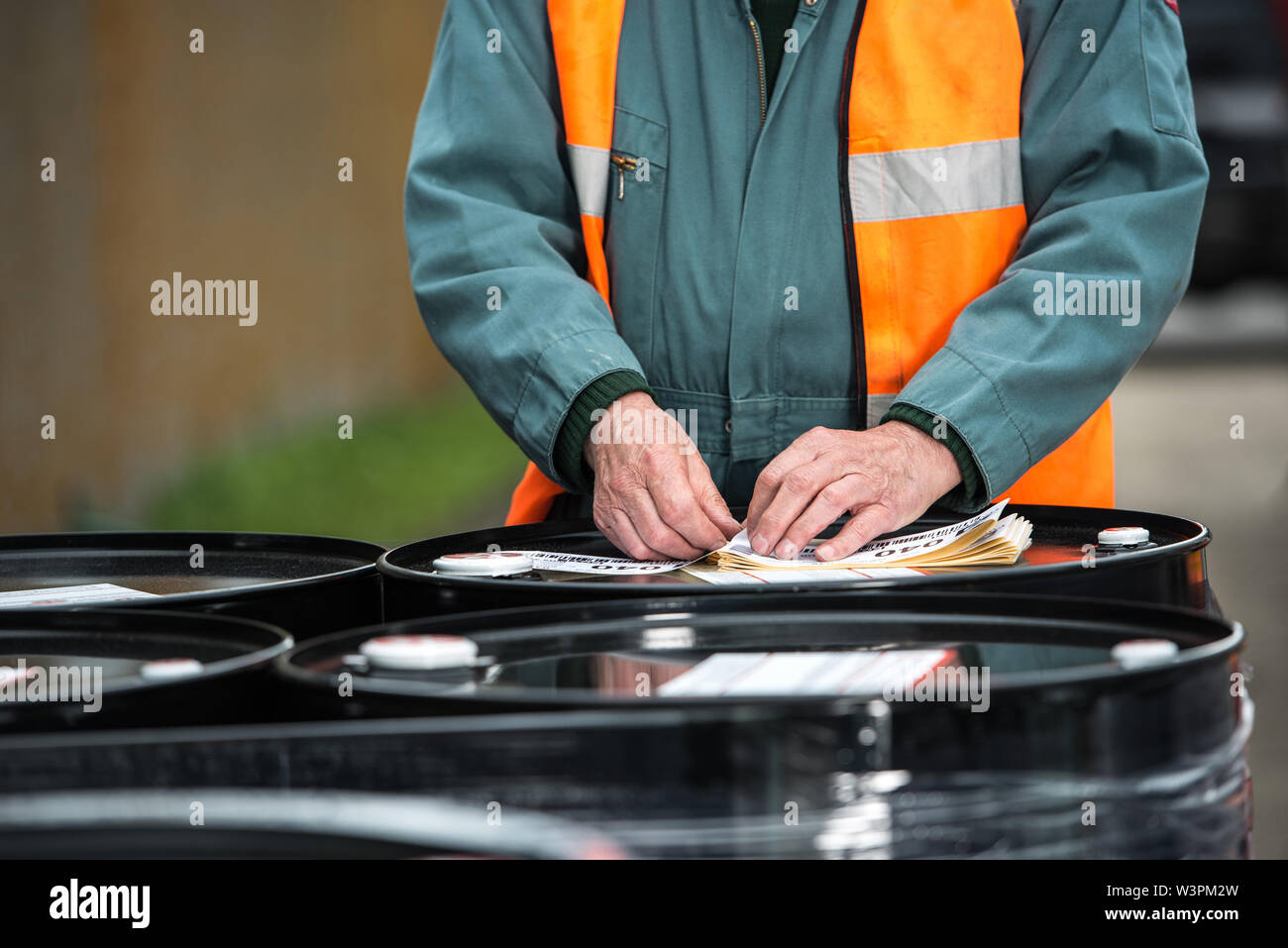 Man anhängen Lieferinformationen Fässer Stockfoto