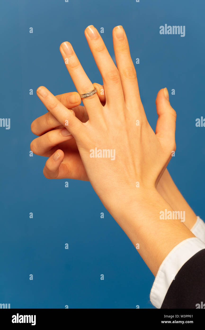 Nahaufnahme der Frau hand Engagement Ring auf der Hochzeit Finger gegen den blauen Hintergrund Stockfoto
