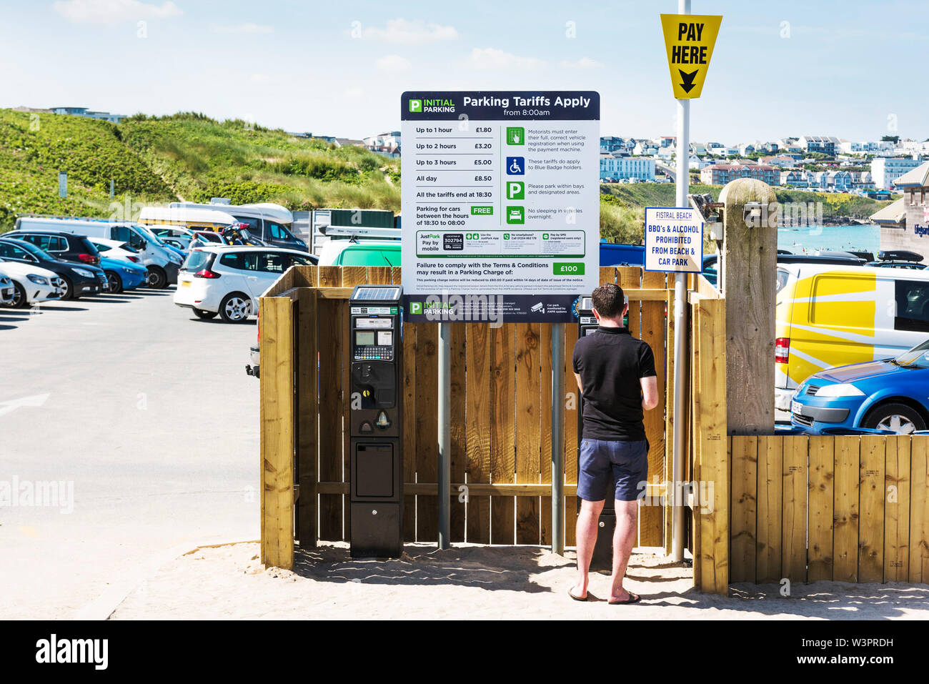Ein Mann zahlt eine Parkgebühr am Parkplatz von Fistral in Newquay in Cornwall. Stockfoto