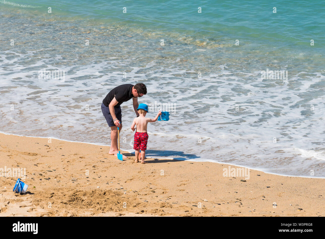 Ein Vater und sein Sohn verbringen einen Urlaub am Fistral Beach in Newquay in Cornwall. Stockfoto