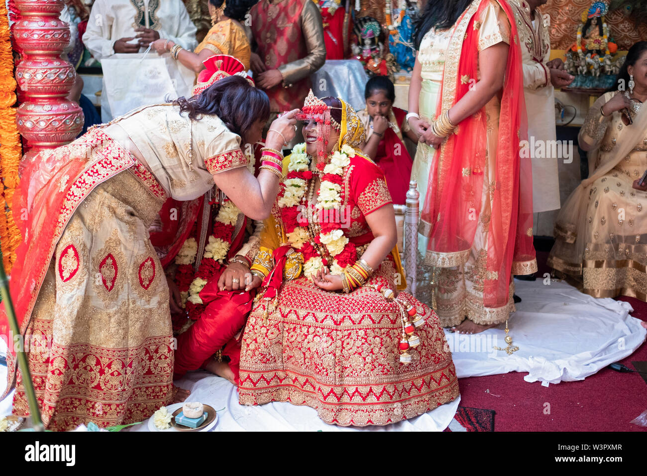 In der Nähe der Abschluss eines traditionellen hinduistischen Hochzeit, Tante hält der Braut verabschieden sie sich für eine persönliche Begrüßung. In Ozone Park, Queens, New York City. Stockfoto