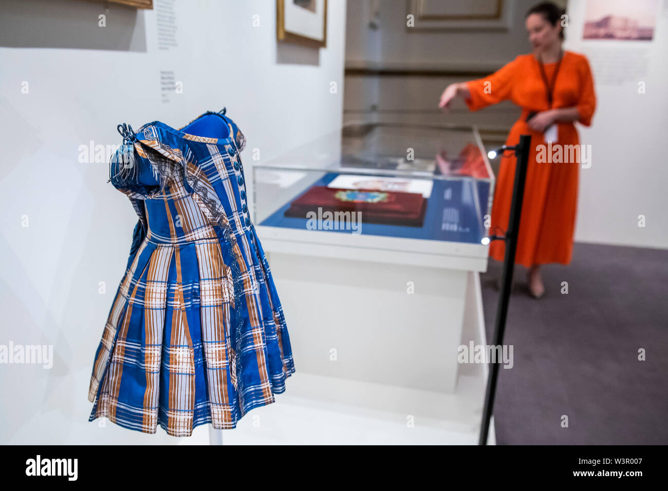 London, Großbritannien. 17. Juli 2019. Der Kurator der Ausstellung erklärt inkl ein Kleid von Albert, Prinz von Wales - der Queen Victoria Palace eine Sonderausstellung auf der diesjährigen Sommer Eröffnung des Buckingham Palace getragen der 200. Jahrestag der Geburt der Queen Victoria zu markieren. Es läuft von 20. Juli bis 29. September 2019 und erzählt die Geschichte, wie der junge Monarch einen ungeliebten königlichen Residenz in der Mitte des sozialen, kulturellen und öffentlichen Leben des Landes geworden. Credit: Guy Bell/Alamy leben Nachrichten Stockfoto