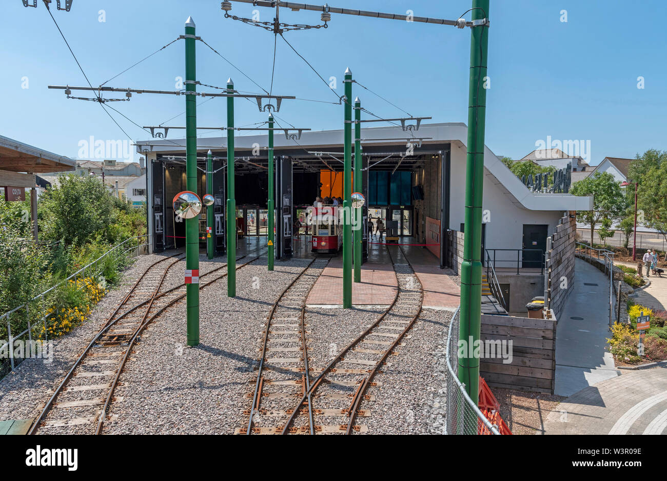 Seaton, Devon, England, UK. Die moderne Seaton Tramway Station Starter für elektrische Straßenbahn fährt. Hinten in der Halle und eine Straßenbahn im Inneren. Stockfoto