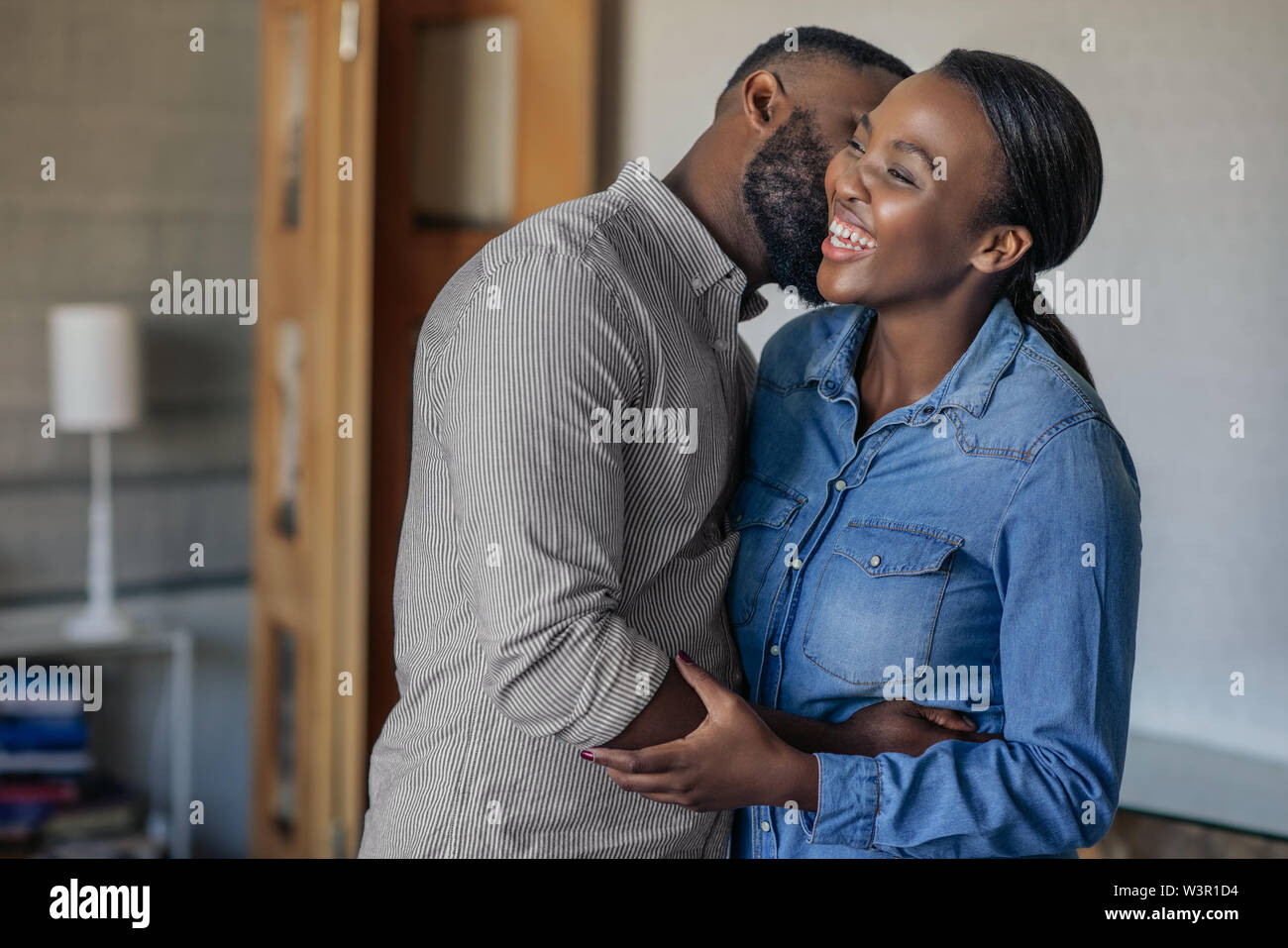 Herzlichen afrikanischen amerikanischen Ehemann seine Frau Küssen auf die Wange Stockfoto