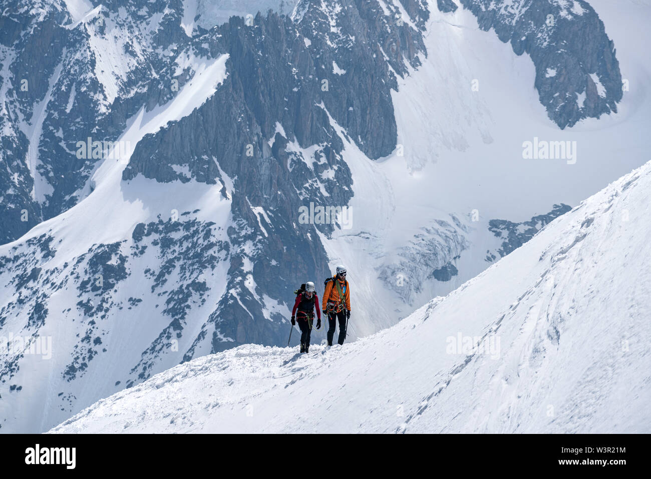 Chamonix, Frankreich - 18.06.2019: Alpinisten auf verschneiten Bergrücken gegen riesige Hintergrund. Stockfoto