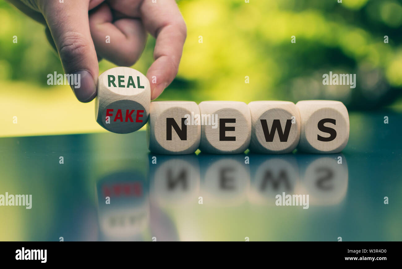 Hand einen Würfel und Änderungen der Ausdruck 'Fake news' auf 'real Nachrichten'. Stockfoto