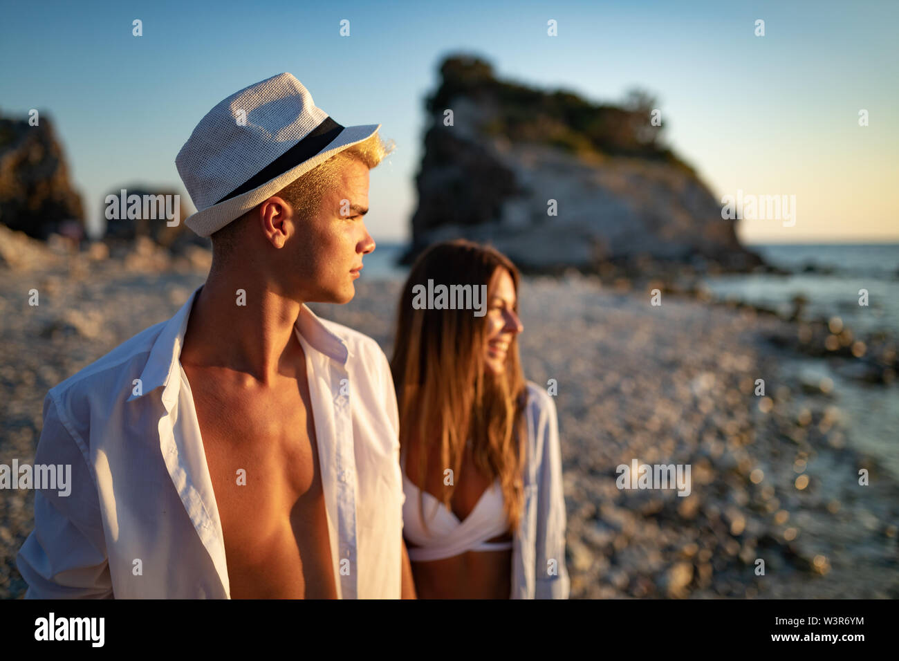 Glückliches junges Paar in Liebe zu Fuß am Meer im Urlaub Stockfoto
