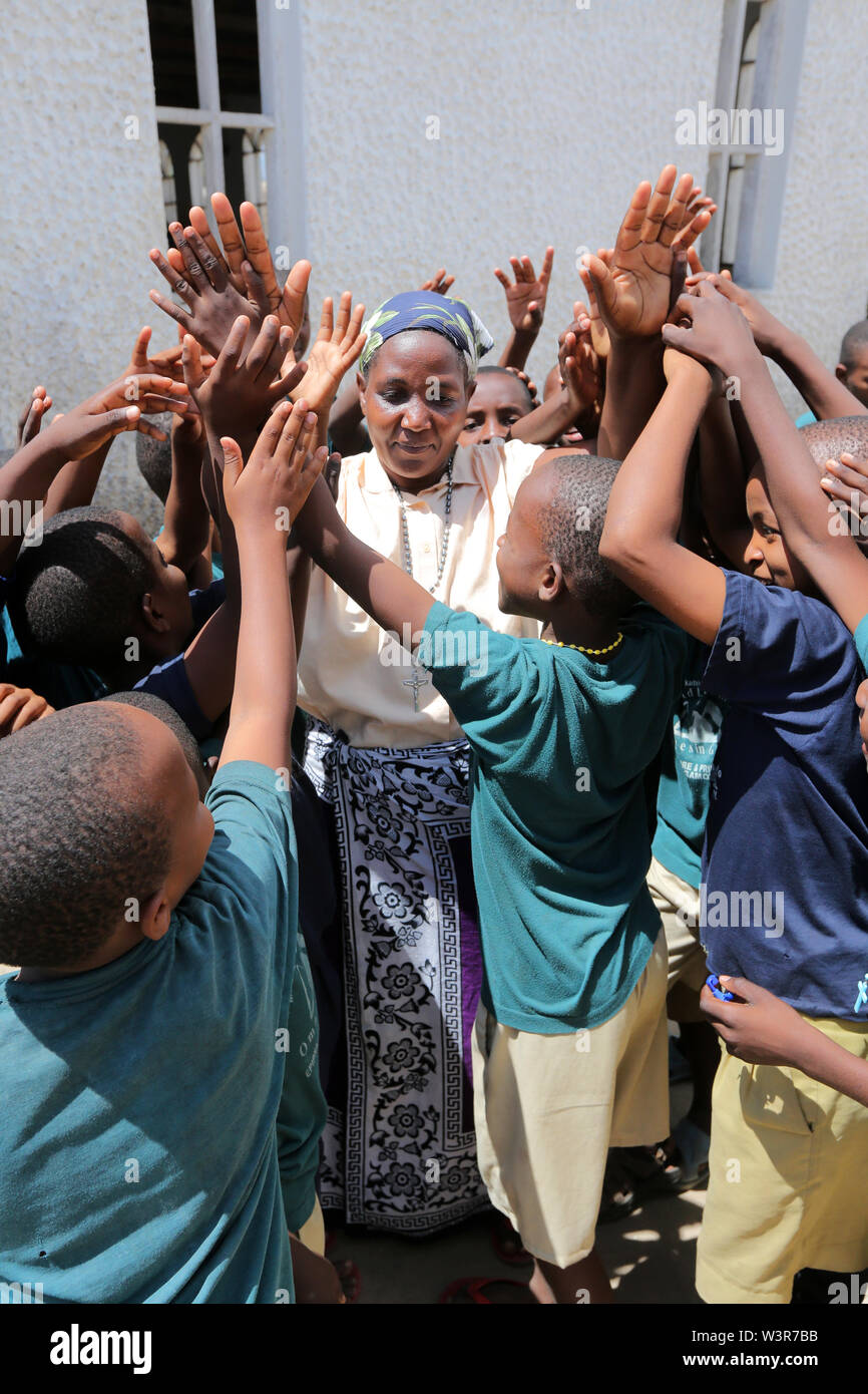 Katholischen Katecheten Religionslehrer wird von Studenten aus Epiphanie Vor- und Grundschule in Bagamoyo begrüßt. Tansania, Afrika Stockfoto