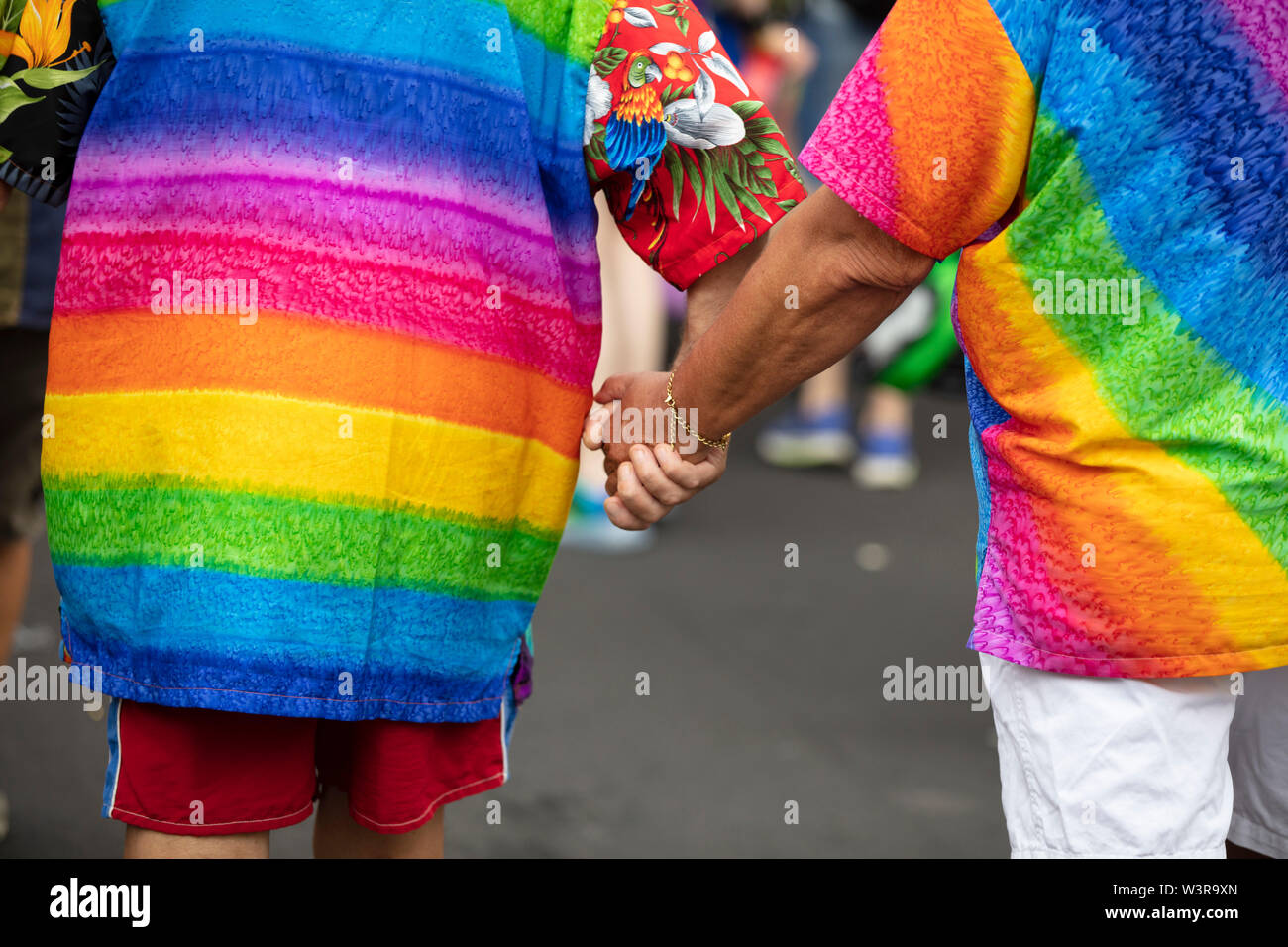 Zwei homosexuelle Männer in Gay Pride flags Hand in Hand mit einander gewickelt Stockfoto