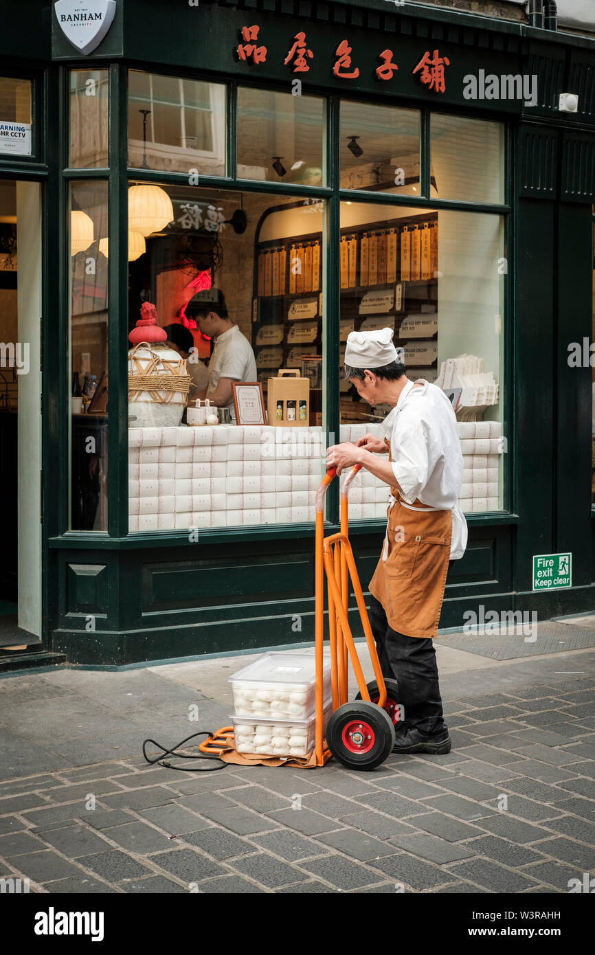 Ältere Chinesen liefert Bao Brötchen an die chinesischen Bäckerei, China Town, London Stockfoto