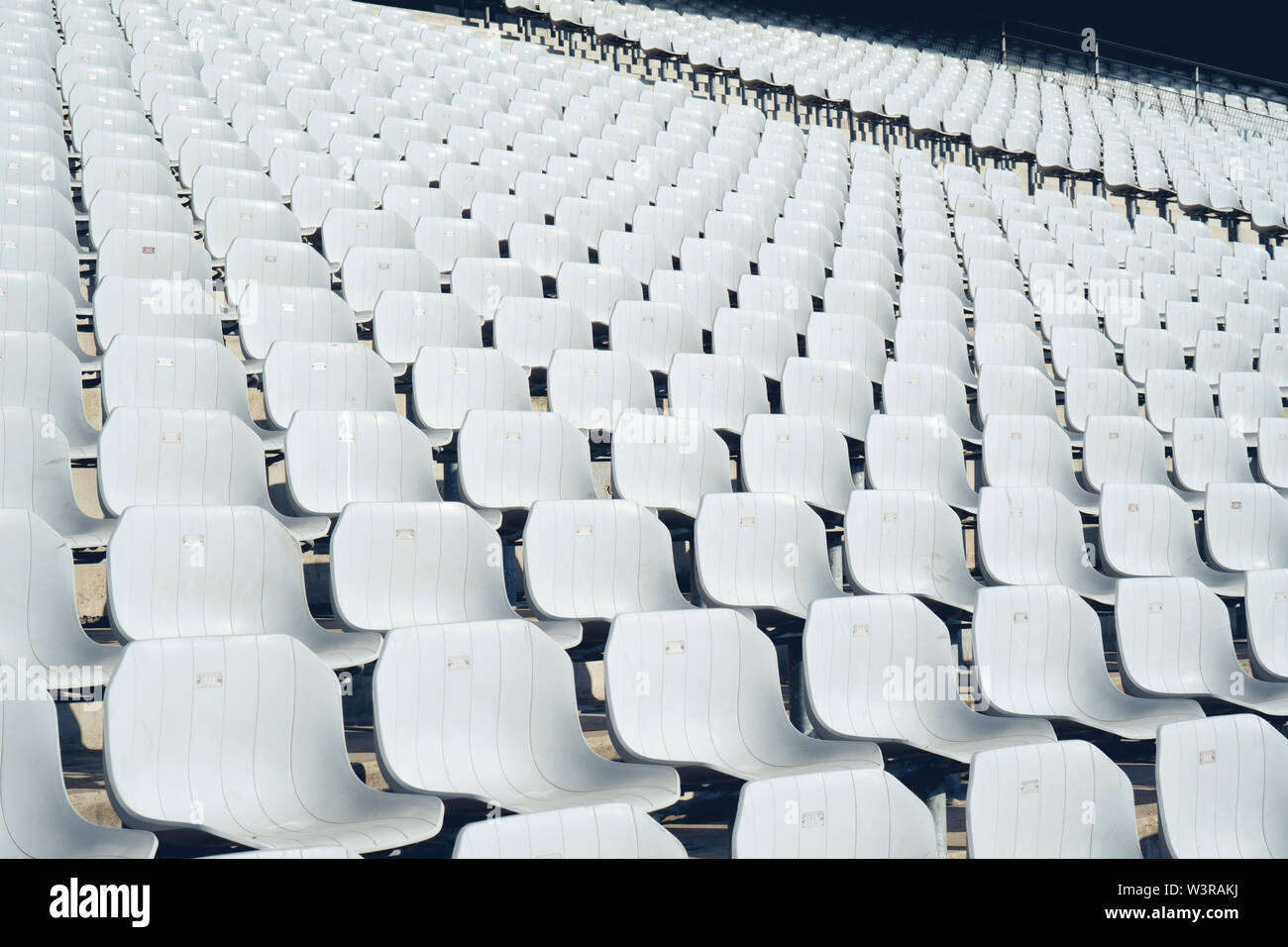 Reihen von leeren Kunststoff weiß Sitzplätze auf der Tribüne in einem offenen Stadion Stockfoto