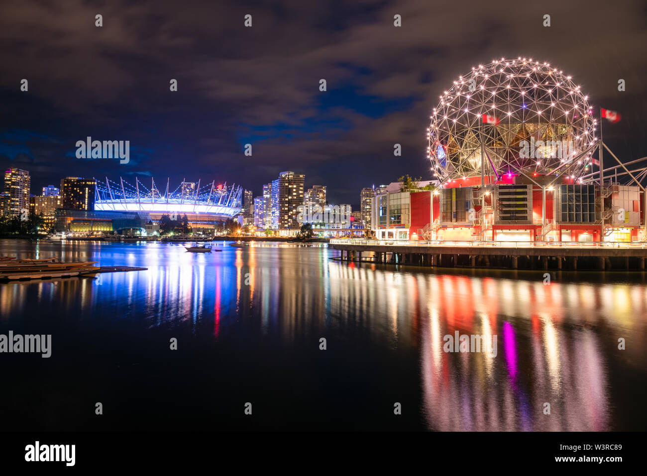 Blick auf die beleuchtete Skyline von Vancouver in der Nacht und der Reflexion im Wasser Stockfoto