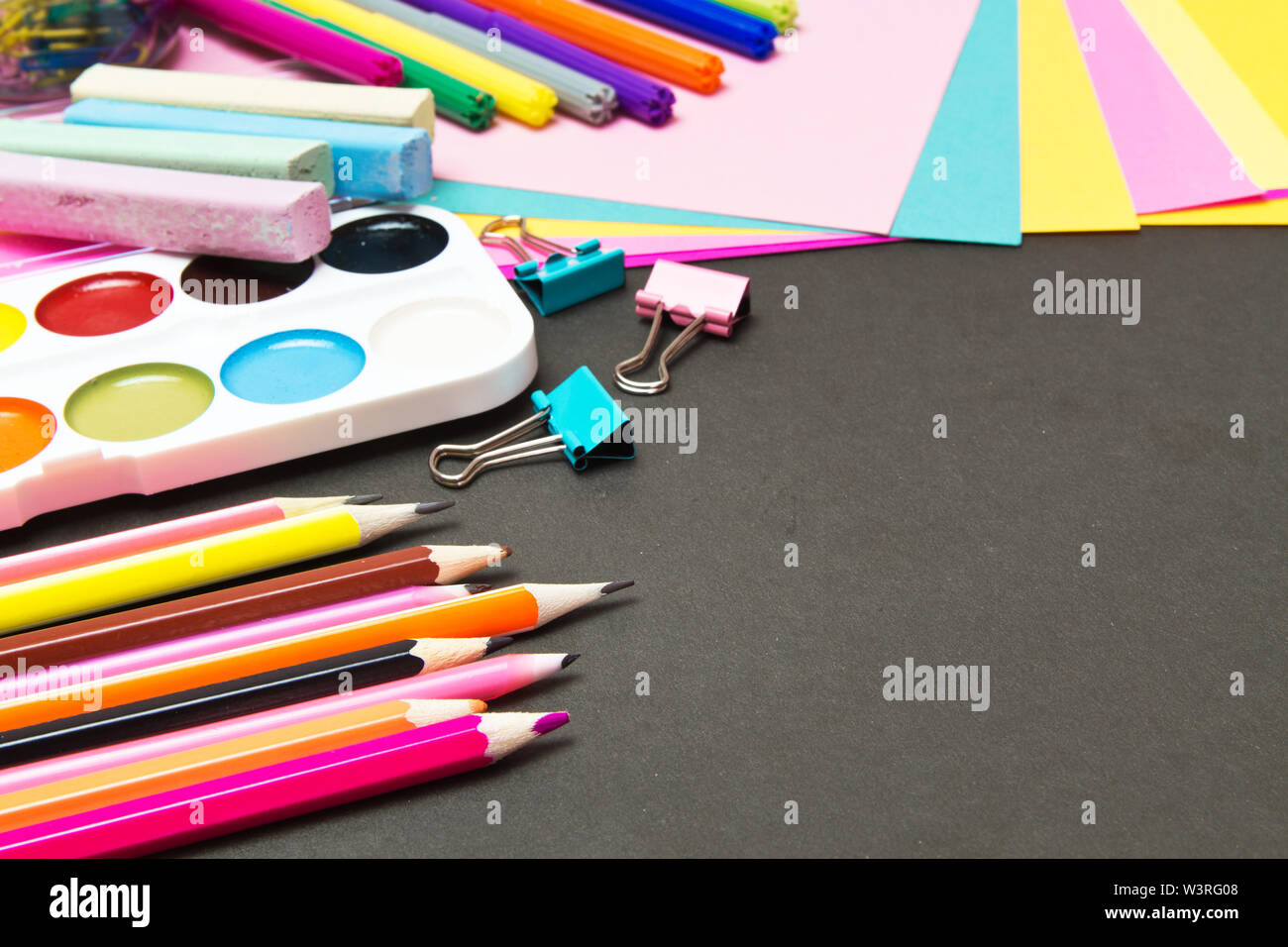 Schul- und Büromaterialien auf einer Tafel. farbiges Papier, Bleistift, Malen, Schreibwaren. Stockfoto