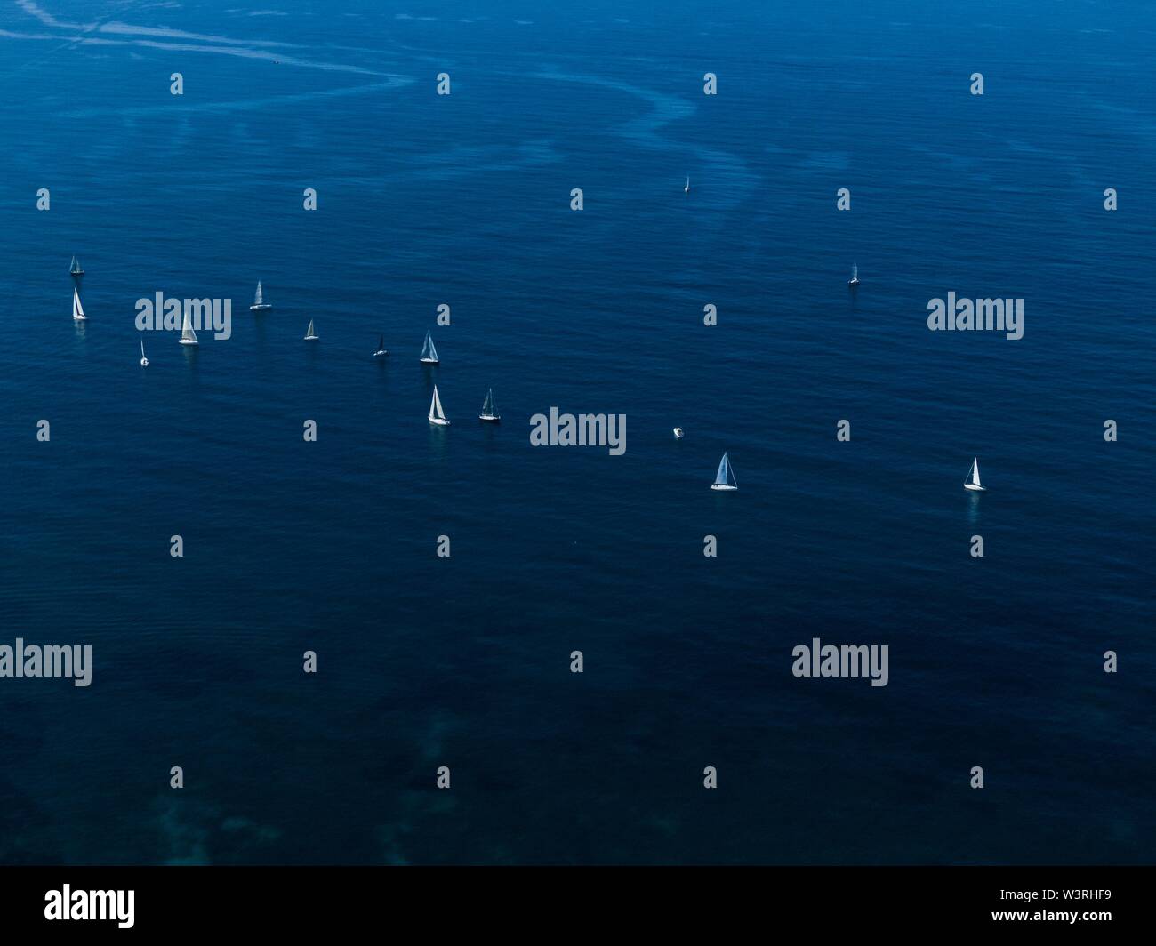 Breite Luftaufnahme von kleinen weißen Segelbooten schwimmend in der meer nah beieinander Stockfoto