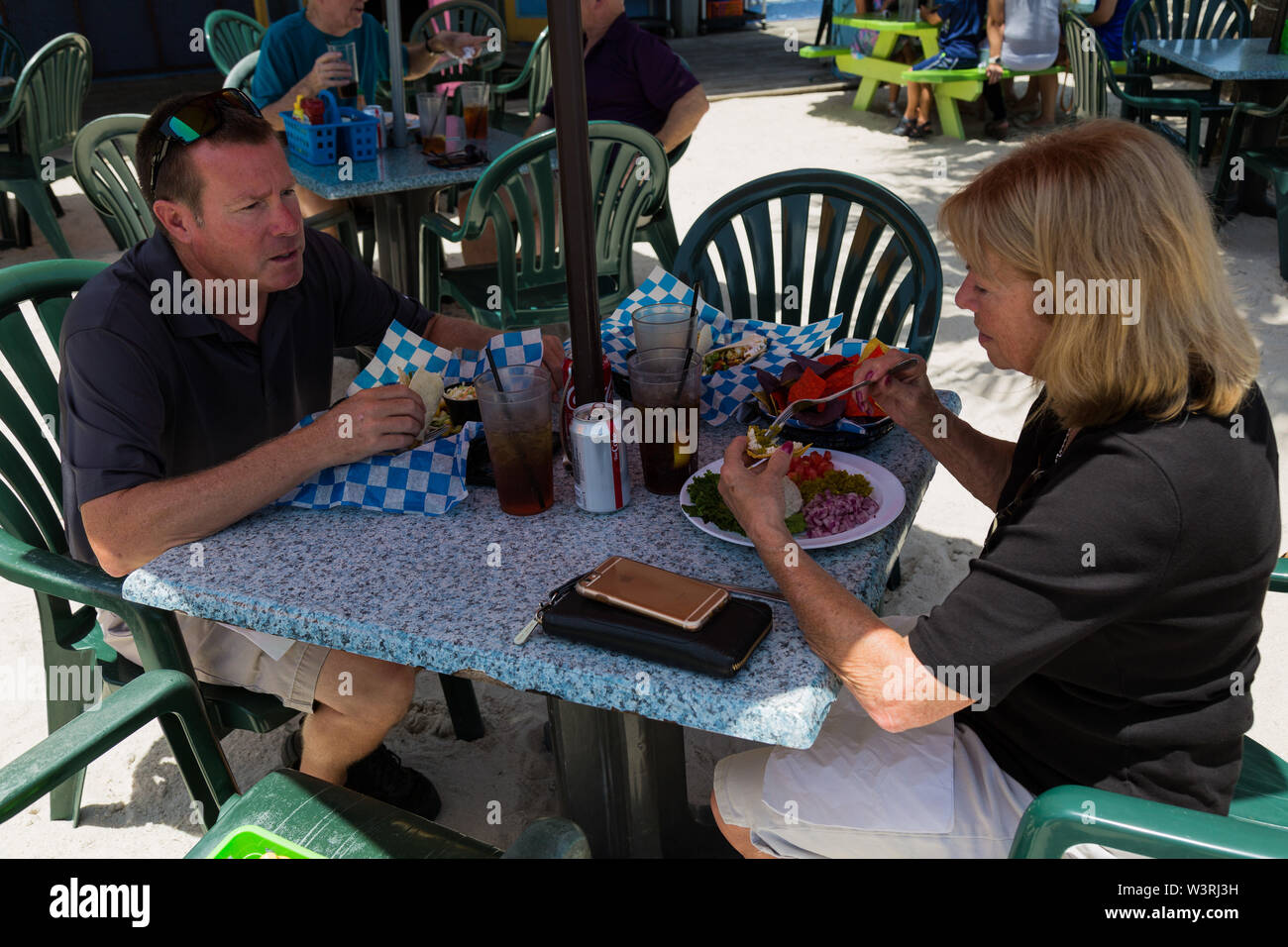 Eine hungrige Mutter und ein Sohn unterhalten sich beim Abendessen im trendigen Pelican Cafe in Stuart, Florida, USA. Stockfoto