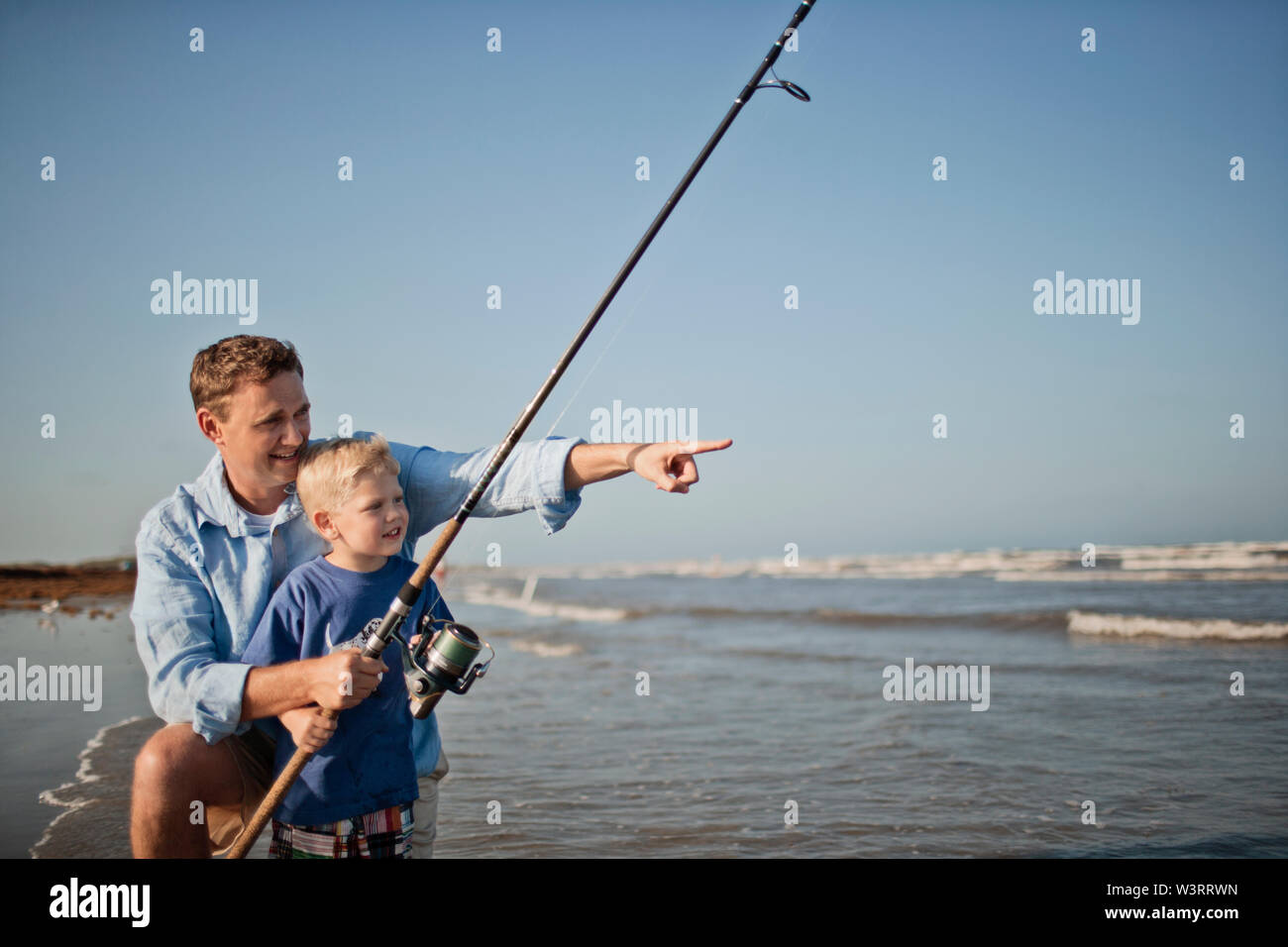 Gerne Vater und Sohn angeln bei Ebbe am Strand. Stockfoto