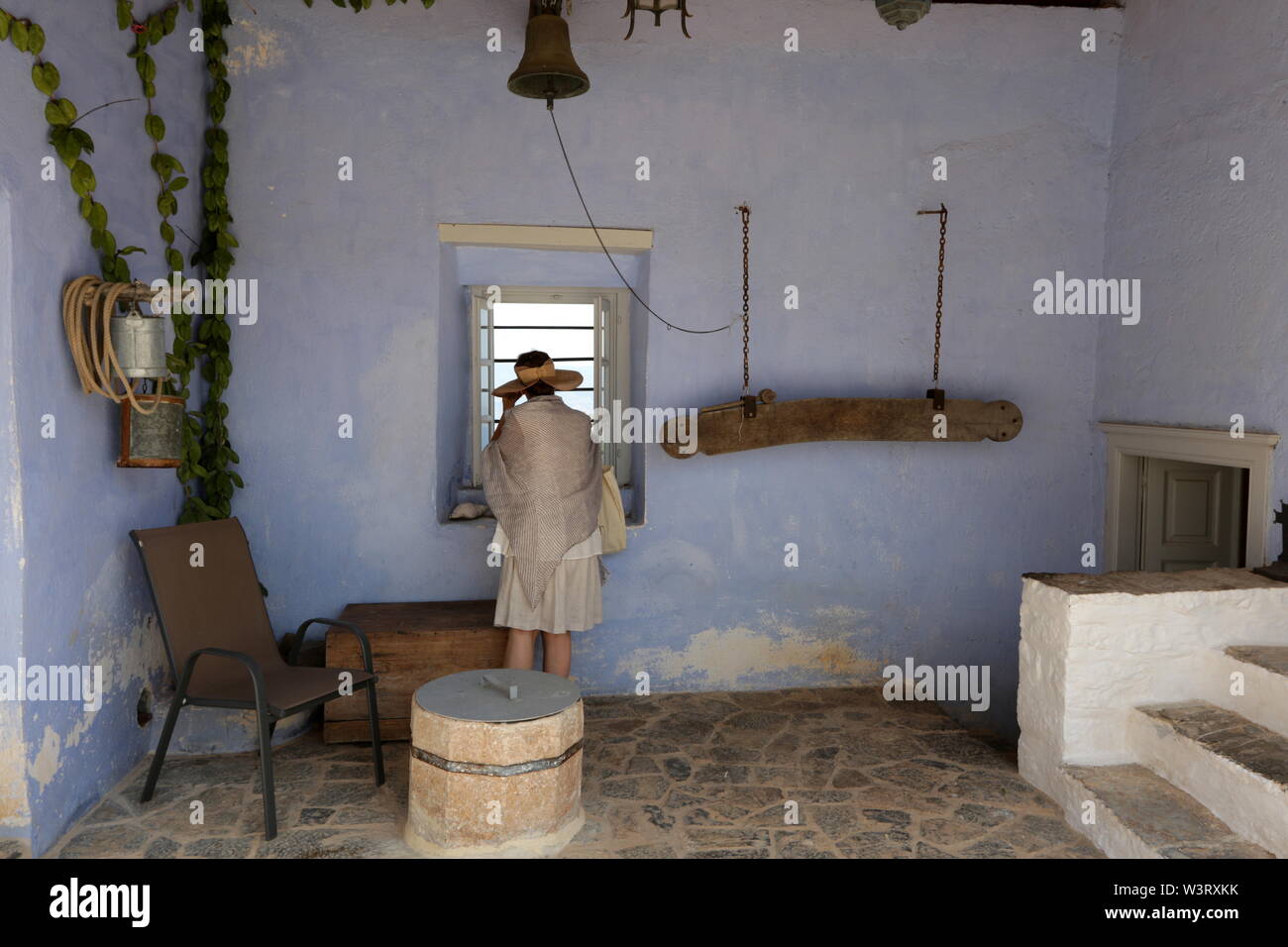 Eine Frau sieht, die durch ein Fenster an der Profitis Ilias (Prophet Elia) Kloster in Hydra Island, Griechenland. Stockfoto