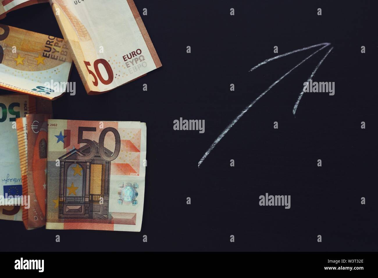 Geld Banknoten und einen Pfeil auf schwarzem Hintergrund. Stockfoto