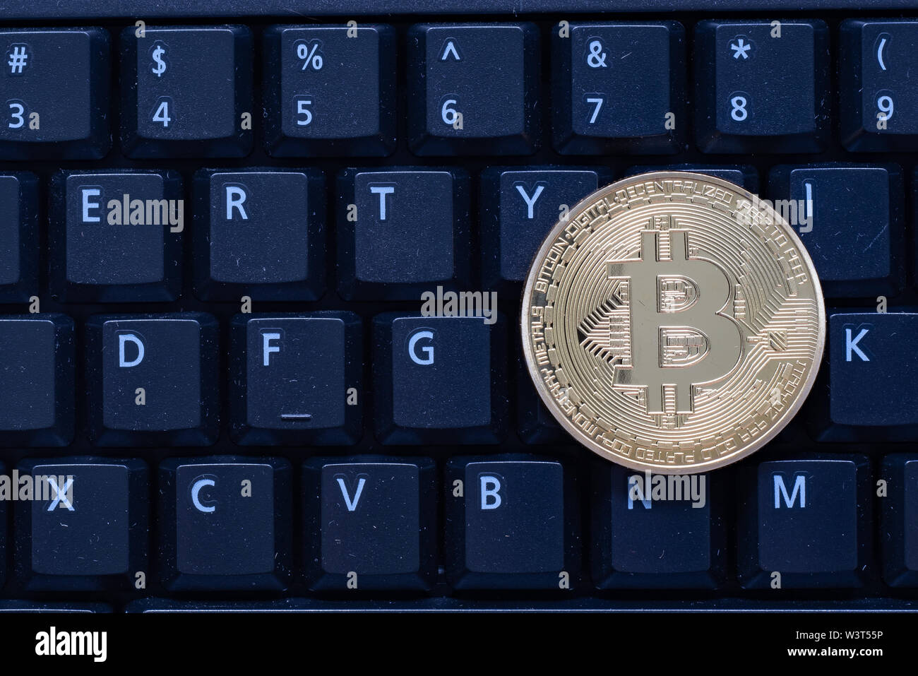 Eine goldfarbene Bitcoin sitzen auf einem Schwarz Computer Tastatur, symbolisch für die cryptocurrency Stockfoto