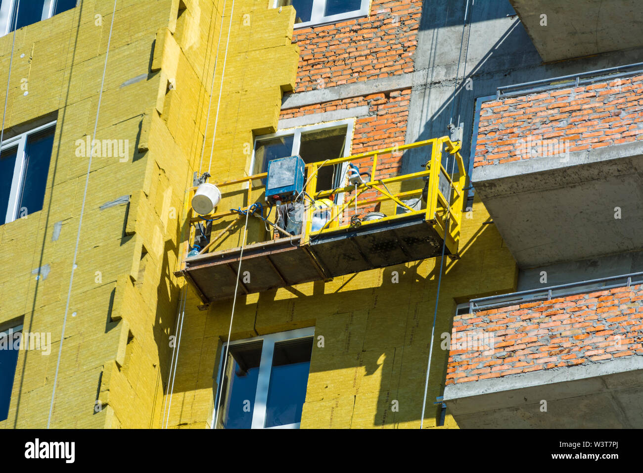 Höhen-Arbeit an den Außenwänden der Glaswolle Dämmung und Putz Stockfoto