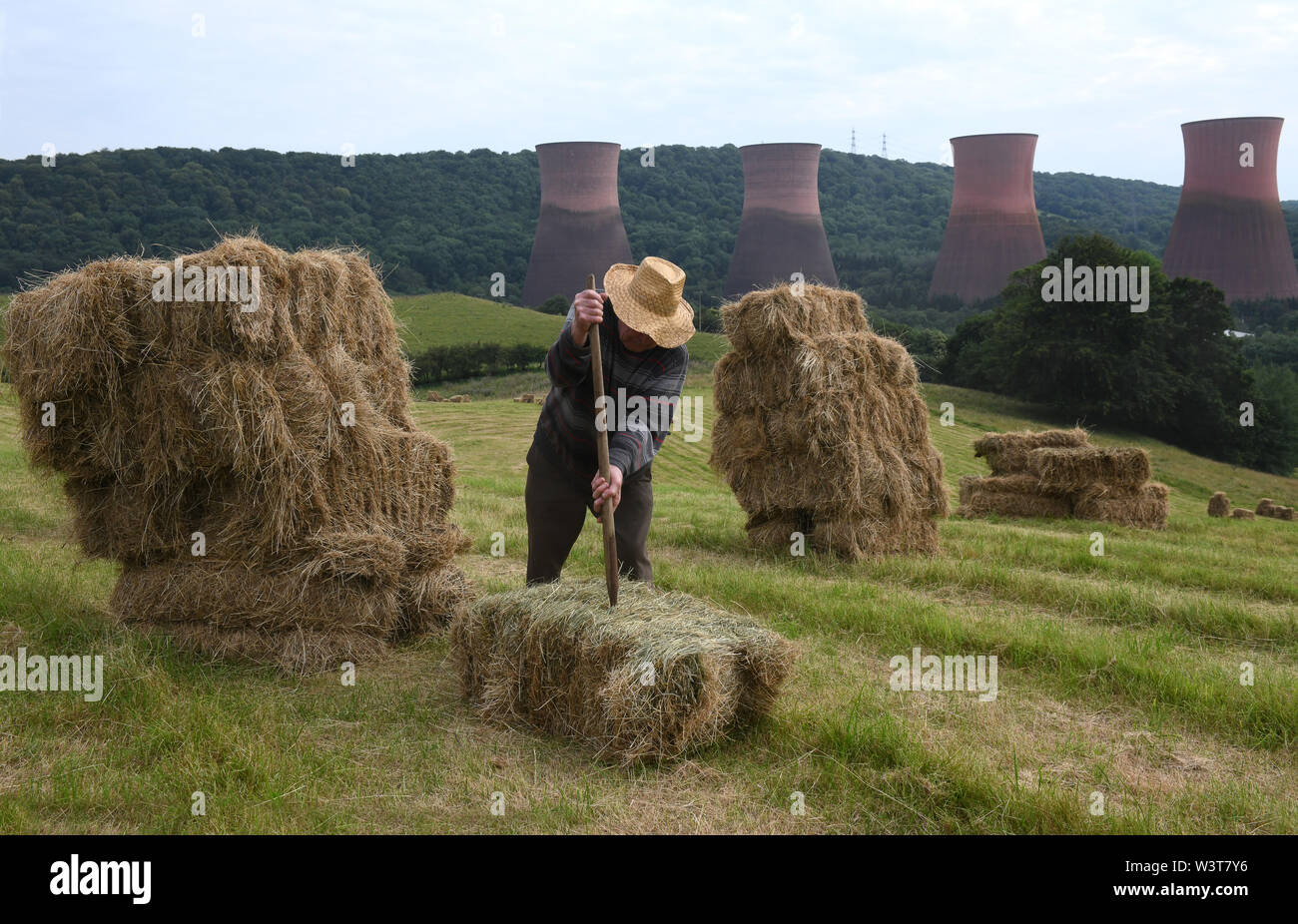 Bauer Stapeln Heuballen von Hand Großbritannien Stockfoto