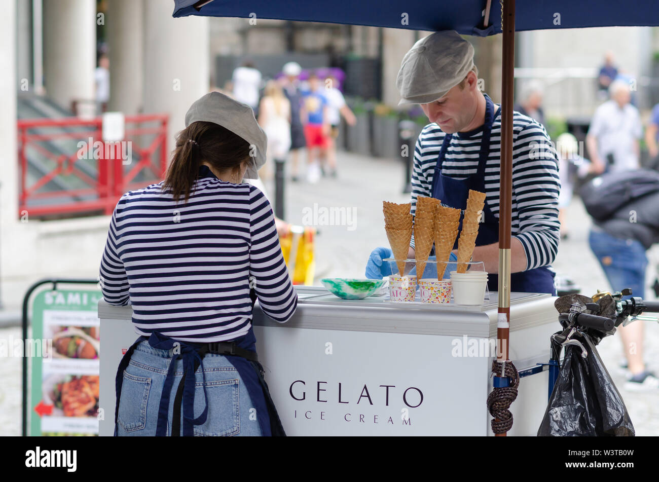 Junge Mädchen und ein Mann verkaufen Gelato Speiseeis in der London Street, in der Nähe der Tower Bridge. Stockfoto