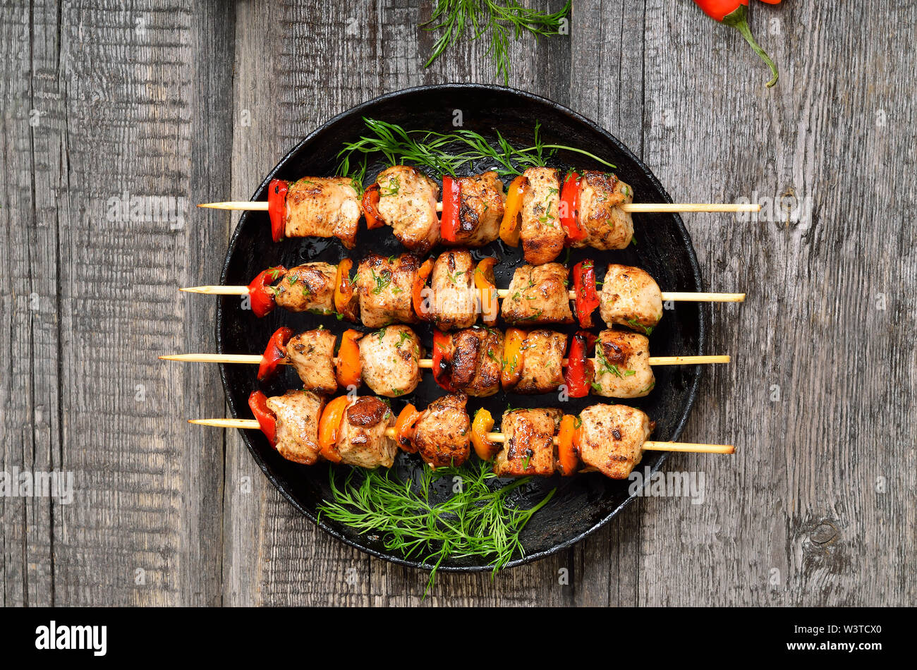 Gegrilltes Hühnchen Kebab mit Gemüse auf Holztisch, Ansicht von oben Stockfoto