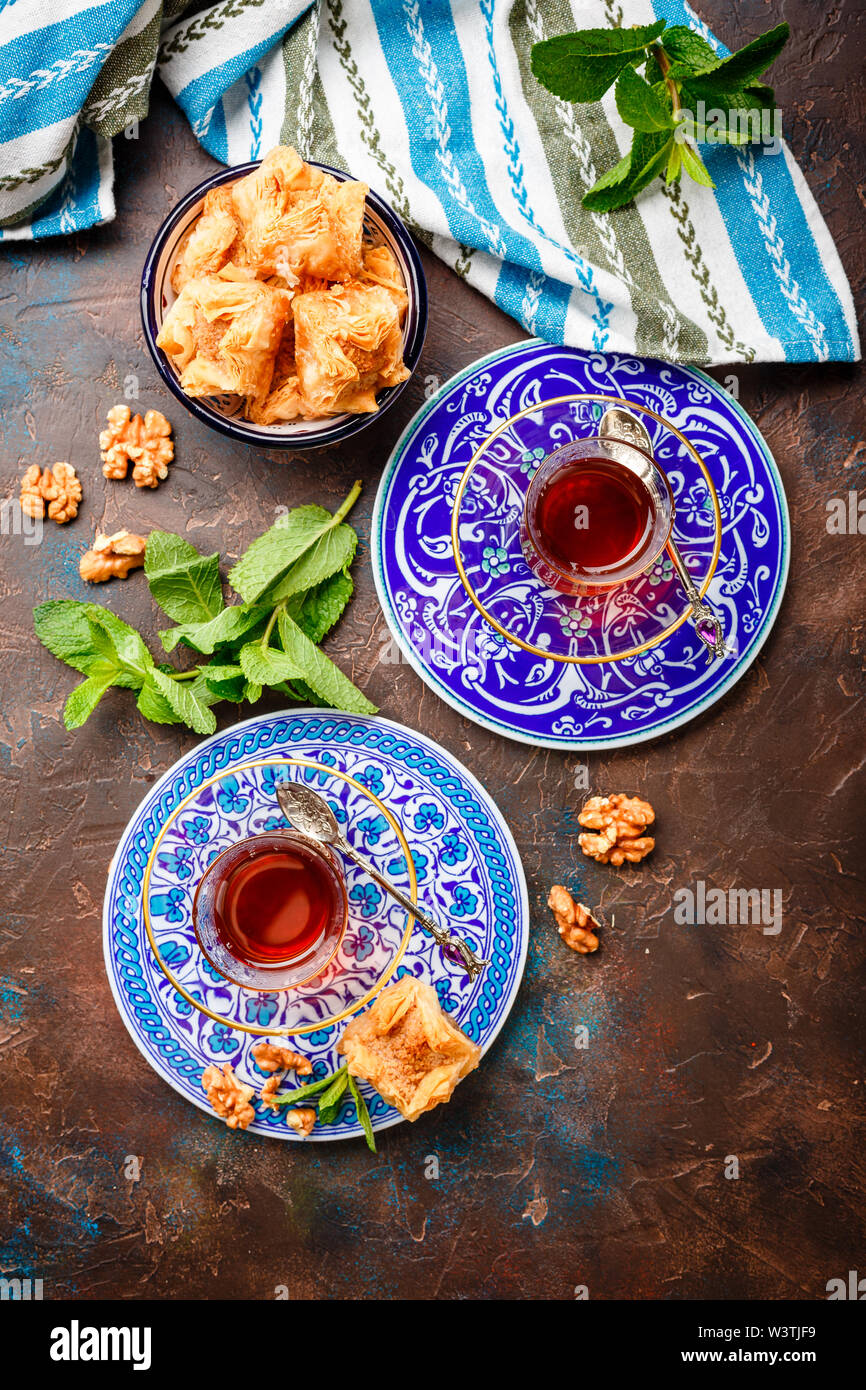 Im Nahen und Mittleren Osten oder arabischen Tee mit Minze in einem traditionellen Glas Schale und Türkische Süßigkeit Baklava. Ramadan Kareem. Eid Mubarak. Islamische Feiertage decorat Stockfoto