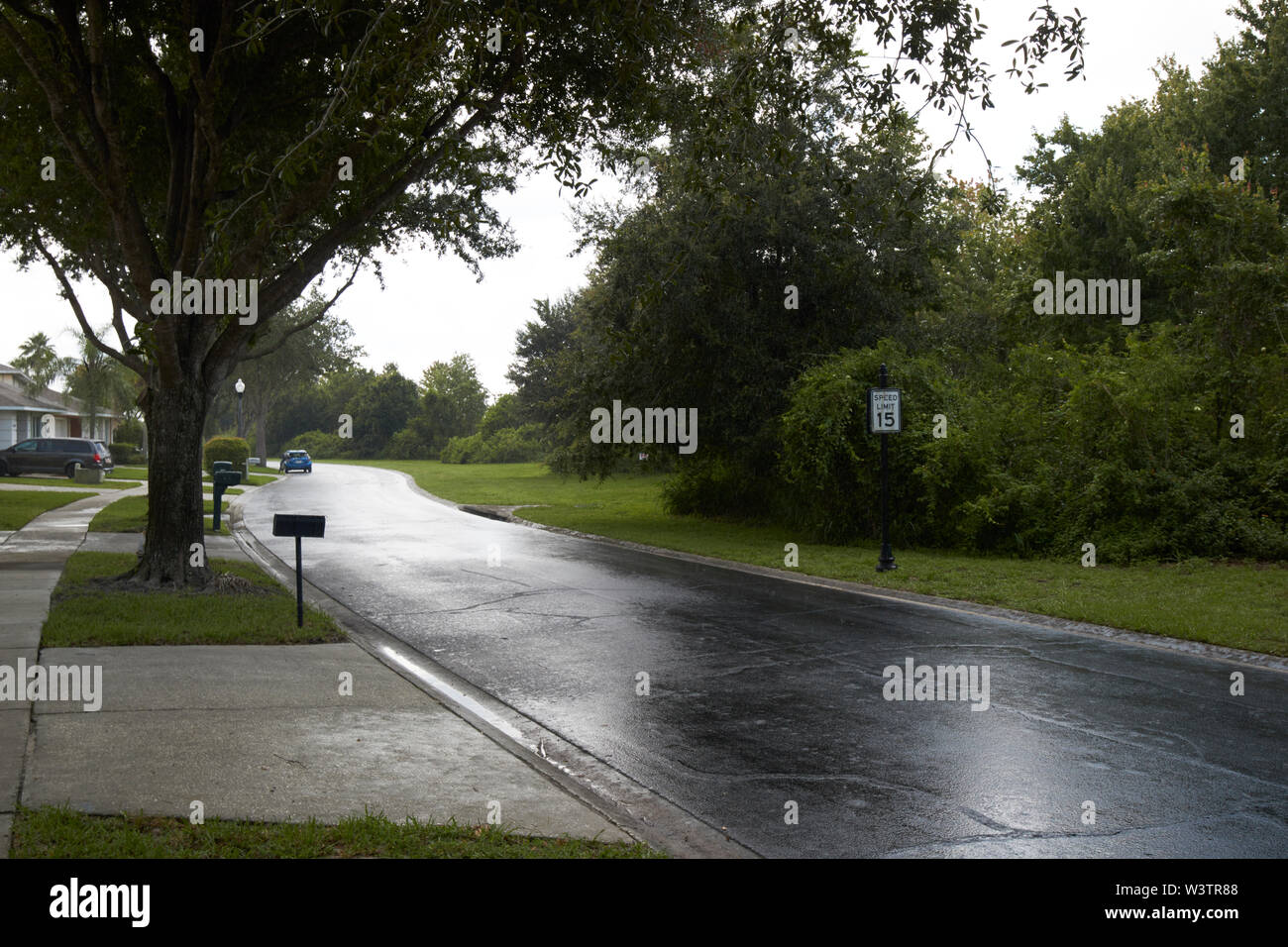 Regen auf Fußweg Bürgersteig durch gated community in Kissimmee während bedeckt stürmischer Sommertag Florida USA Vereinigte Staaten von Amerika Stockfoto