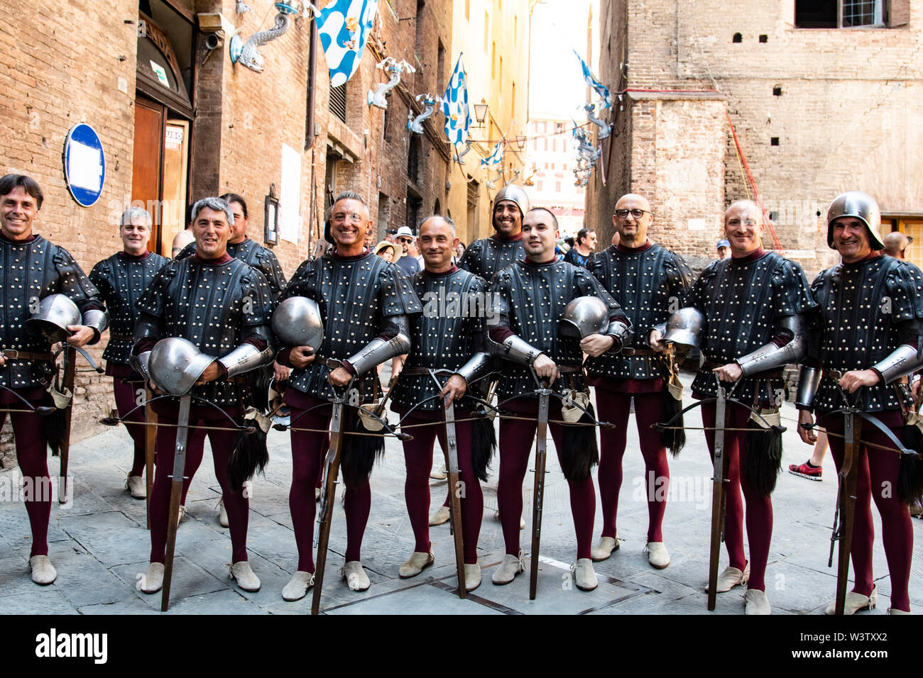 Männer in historischen mittelalterlichen Kostümen Linie bis zur Vorbereitung für die Parade des Palio durch die Straßen von Siena, Italien Stockfoto