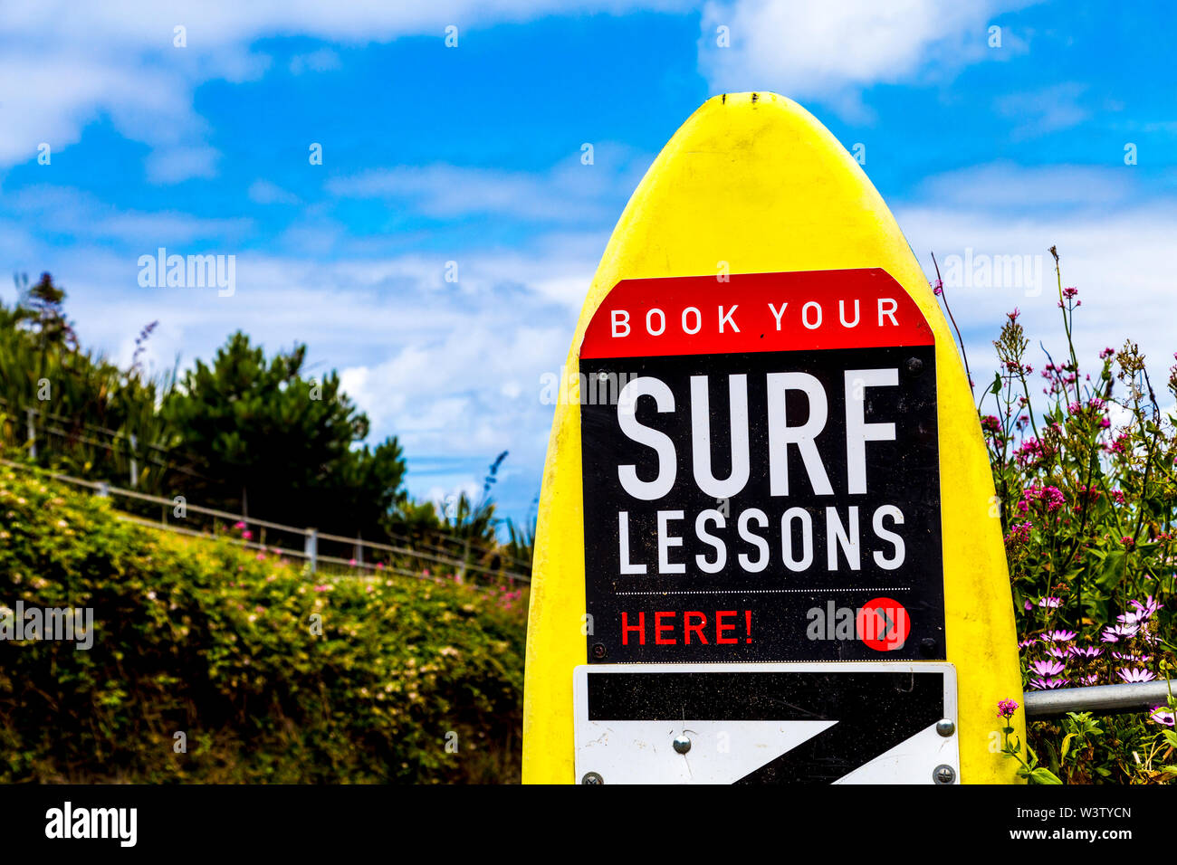 Zeichen für Surfkurse auf einem Surfbrett in Newquay, Cornwall, Großbritannien Stockfoto