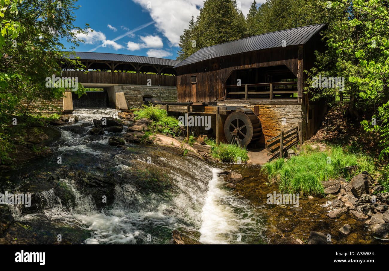 Historische alte Sägemühle mit Wasserrad und Wasserfällen Stockfoto