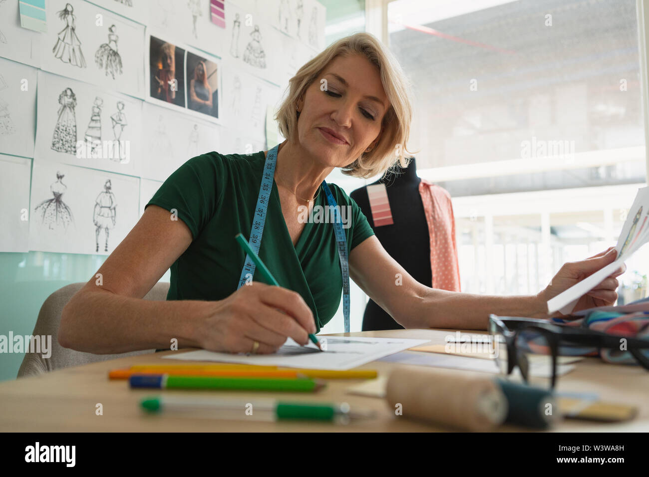 Weibliche Mode Designer Zeichnung Skizze auf einer Tabelle Stockfoto