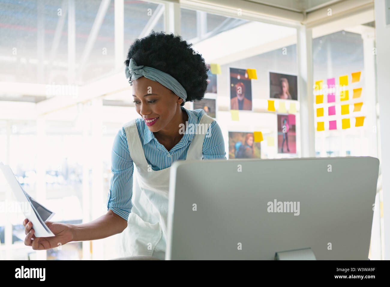 Weibliche Graphic Designer das Betrachten von Fotos während der Arbeit am Computer am Schreibtisch Stockfoto