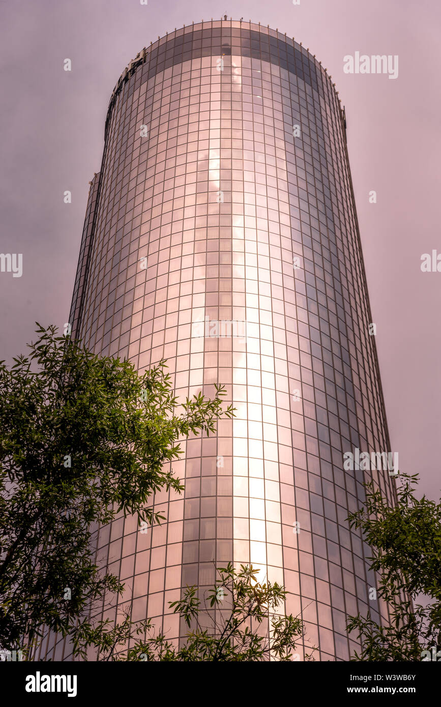 Reflexion von Wolken und Stadt in modernes Gebäude bei Sonnenuntergang Stockfoto