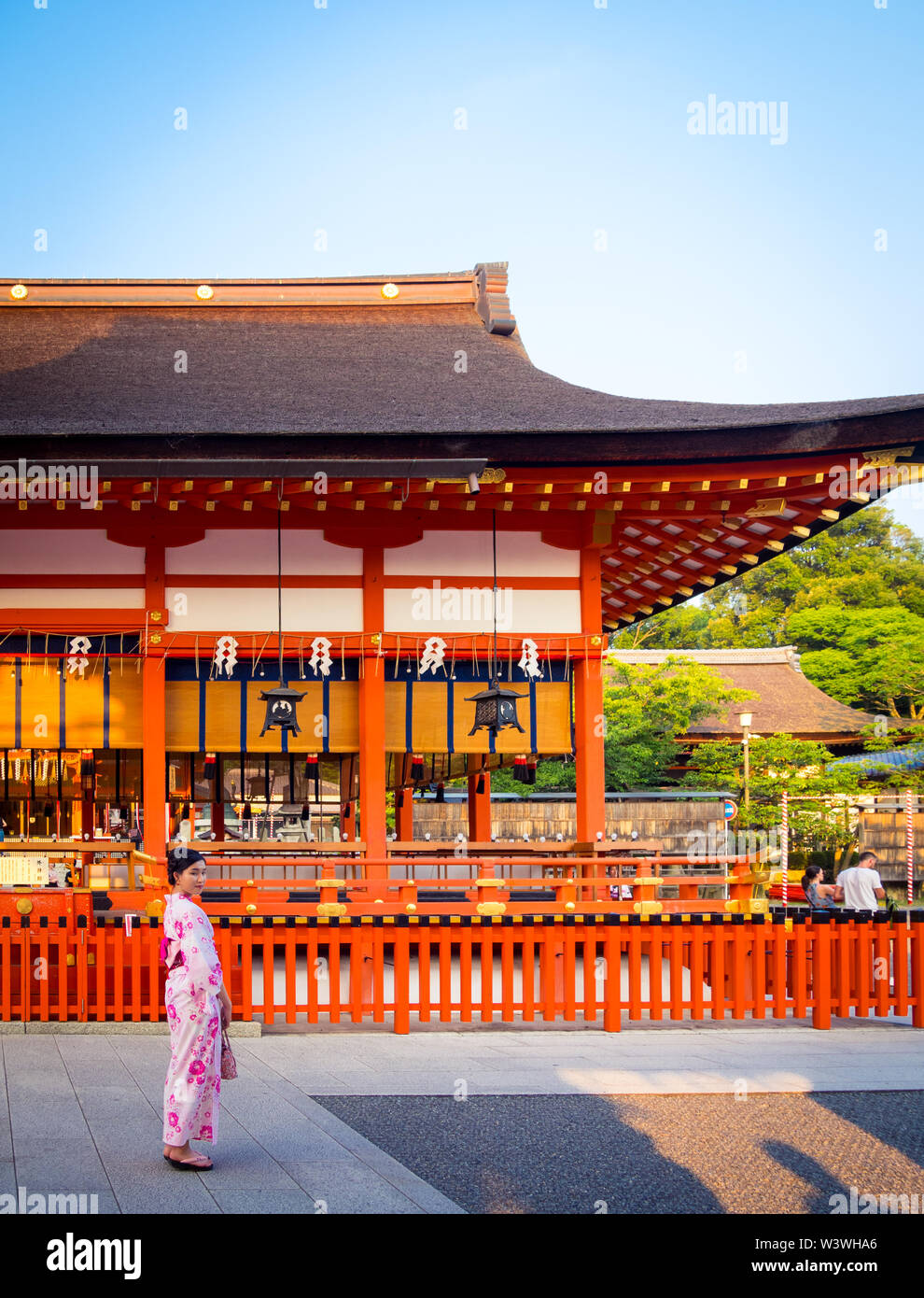 Ein japanisches Mädchen kleidet sich im Sommer vor dem Romon-Tor (Haupttor) des Fushimi Inari-Taisha-Schreins in der Nähe von Kyoto, Japan. Stockfoto