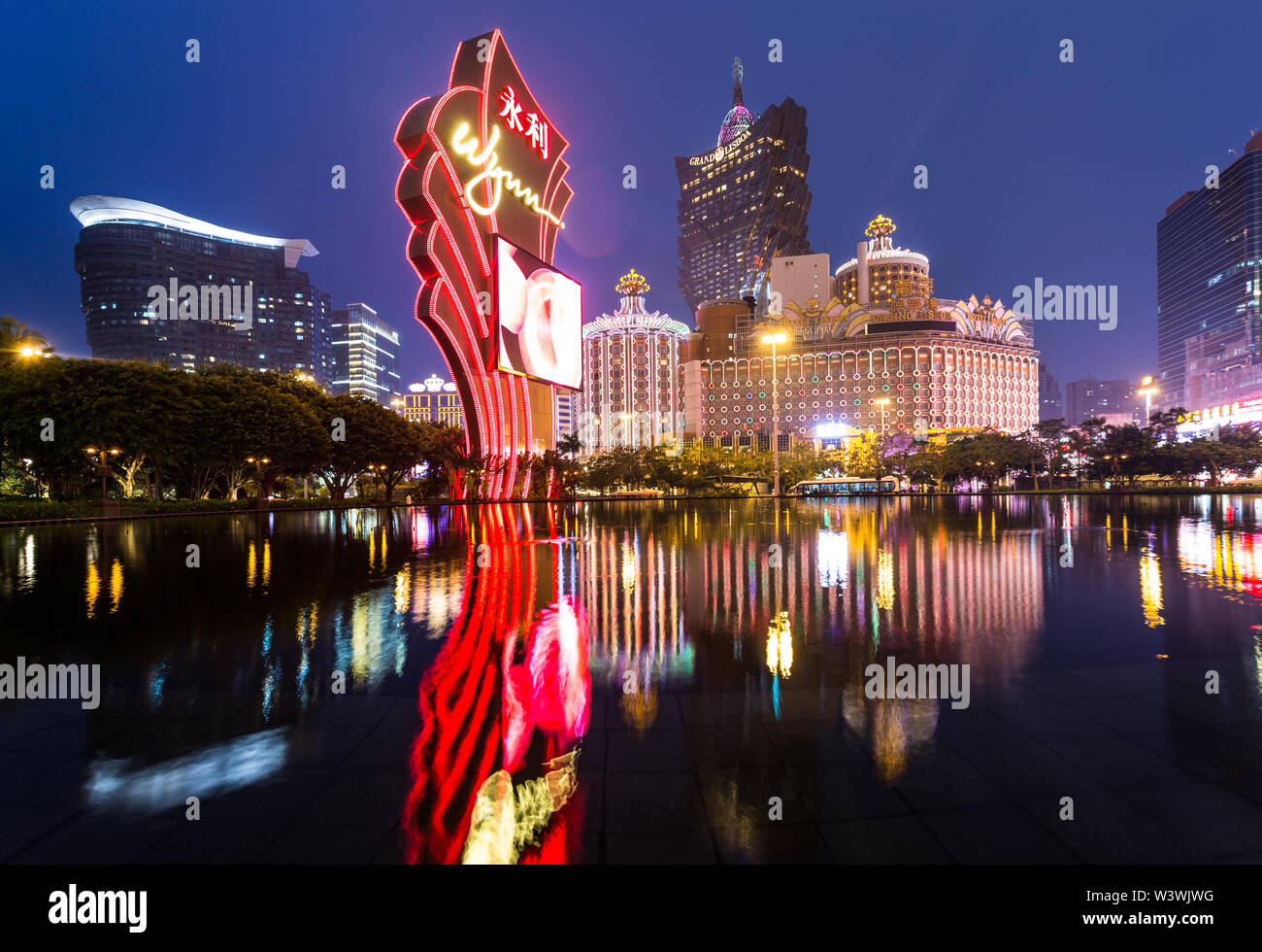Macao, CHINA - 23. April 2017: Die Lichter von einem berühmten Casino-Betreiber Wynn reflektieren auf dem Wasser mit dem Lisboa Casino-Turm im Hintergrund. Macau rece Stockfoto