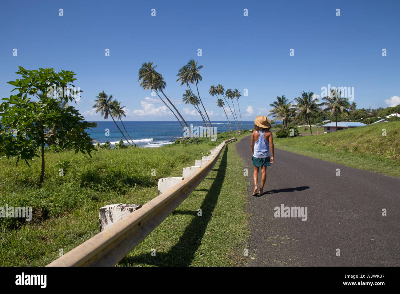 Ein Kerl, zu Fuß die Straße runter von Samoa, neben dem Meer, Samoa Stockfoto