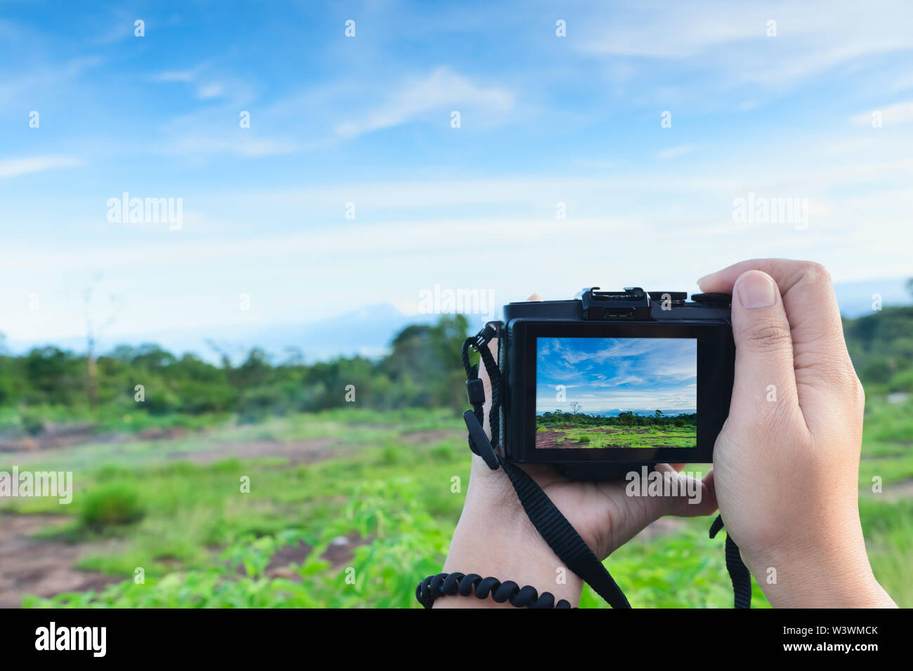 Reisende machen Foto mit spiegellosen Kamera in der Hand, Travel Blogger, Nahaufnahme von Frauen Hände halten spiegellosen Kamera unter Bild bei Phuhinron Stockfoto