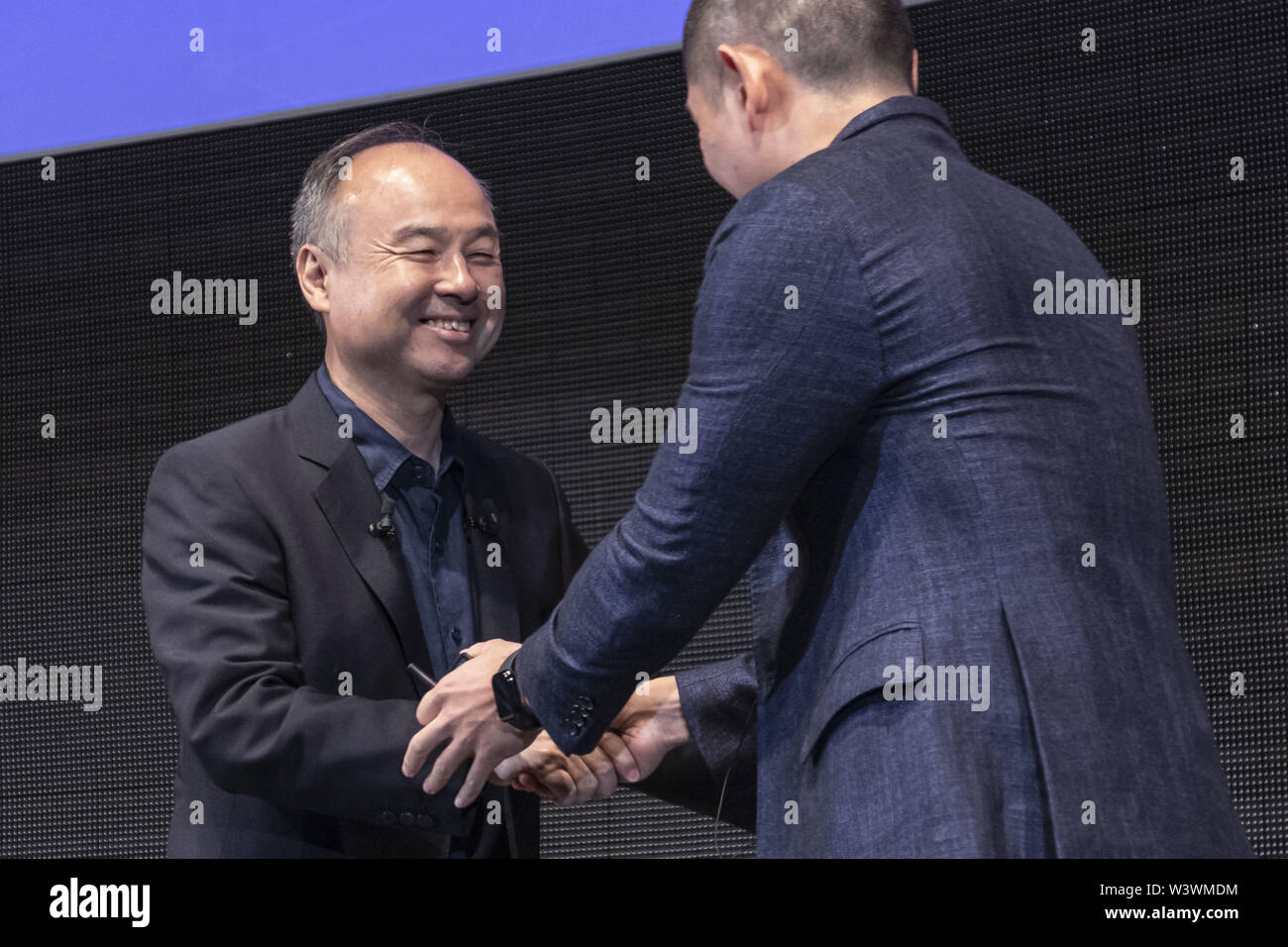 Tokio, Japan. 18 Juli, 2019. (L und R) Anthony Tan Group CEO und Mitbegründer der Greifer schüttelt Hände mit Masayoshi Son Vorsitzender und CEO von SoftBank während der SoftBank Welt 2019 Veranstaltung in Tokio. Die jährliche Veranstaltung wird von SoftBank Corp. organisierte KI (Künstliche Intelligenz) und IoT (Internet der Dinge) Unternehmen, die die neueste Technologie für Roboter in verschiedenen Geschäftsbereichen einzuführen. Der Roboter Expo läuft noch bis zum 19. Juli. Credit: Rodrigo Reyes Marin/ZUMA Draht/Alamy leben Nachrichten Stockfoto