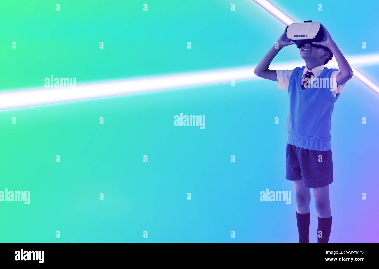 Das zusammengesetzte Bild der vollen Länge der Schule junge tragen virtual reality Headset Stockfoto