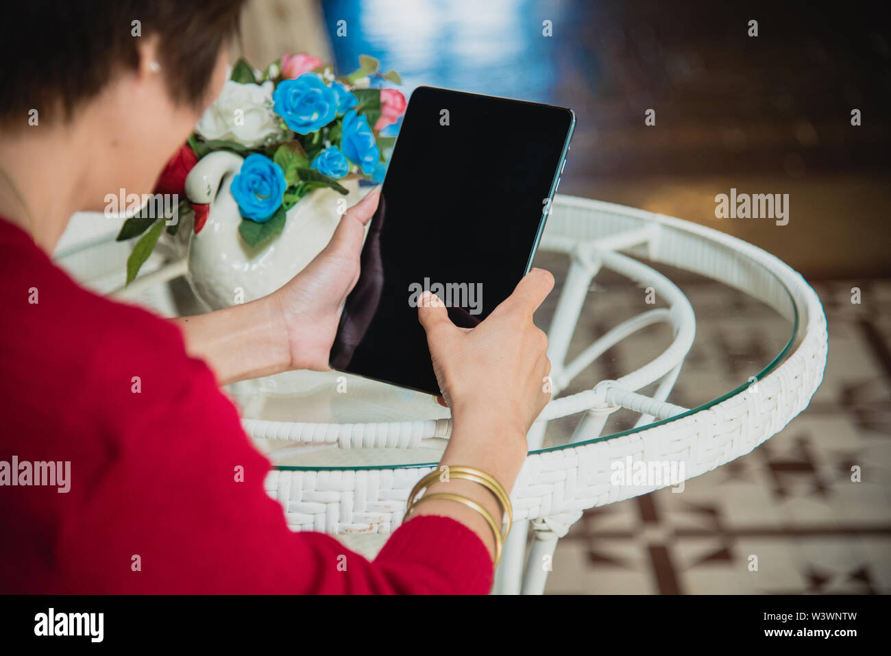 Chinesische Geschäftsfrau Arbeiten an Tablet Computer außerhalb der. Wunderschöne Frau tragen rote T-Shirt Arbeiten im Freien. Stockfoto